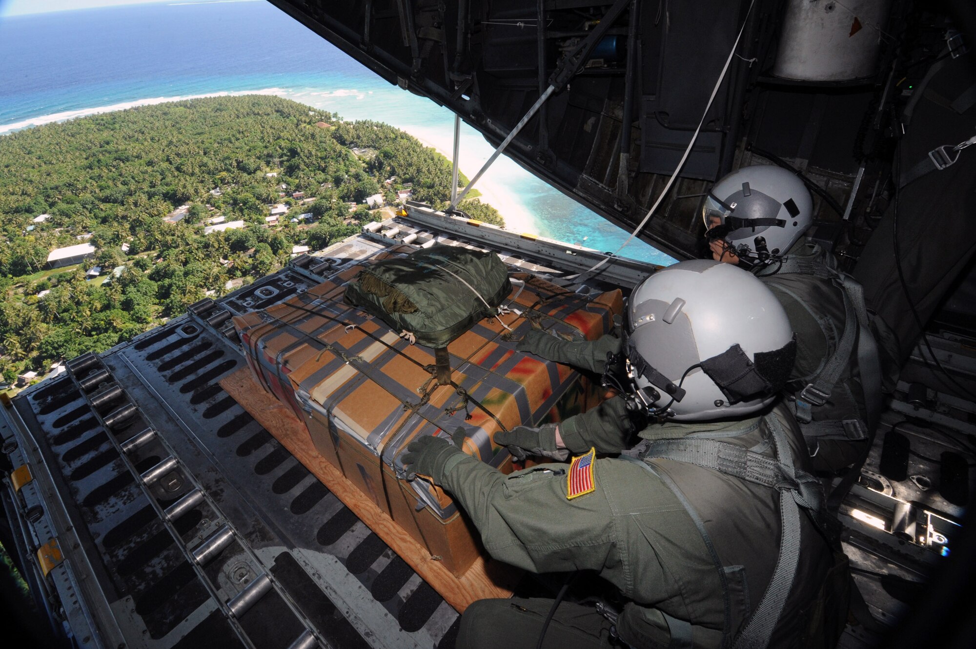 Tech. Sgt. Heath Bahyi and another crewmember wait for the right moment to push a boxed pallet of donated supplies from a C-130 Hercules during the 2008 Operation Christmas Drop Dec. 19 over the remote Island of Yap. Through military and local community support, the operation collected tens of thousands of donated items and raised more than $30,000 in support. Airmen today continue the tradition of delivering supplies to remote islands of the Commonwealth of the Northern Marianas Islands, Yap, Palau, Chuuk and Pohnpei. Sergeant Bahyi is a loadmaster from the 36th Airlift Squadron from Yokota Air Base, Japan. (U.S. Air Force photo/Master Sgt. Kevin J. Gruenwald)