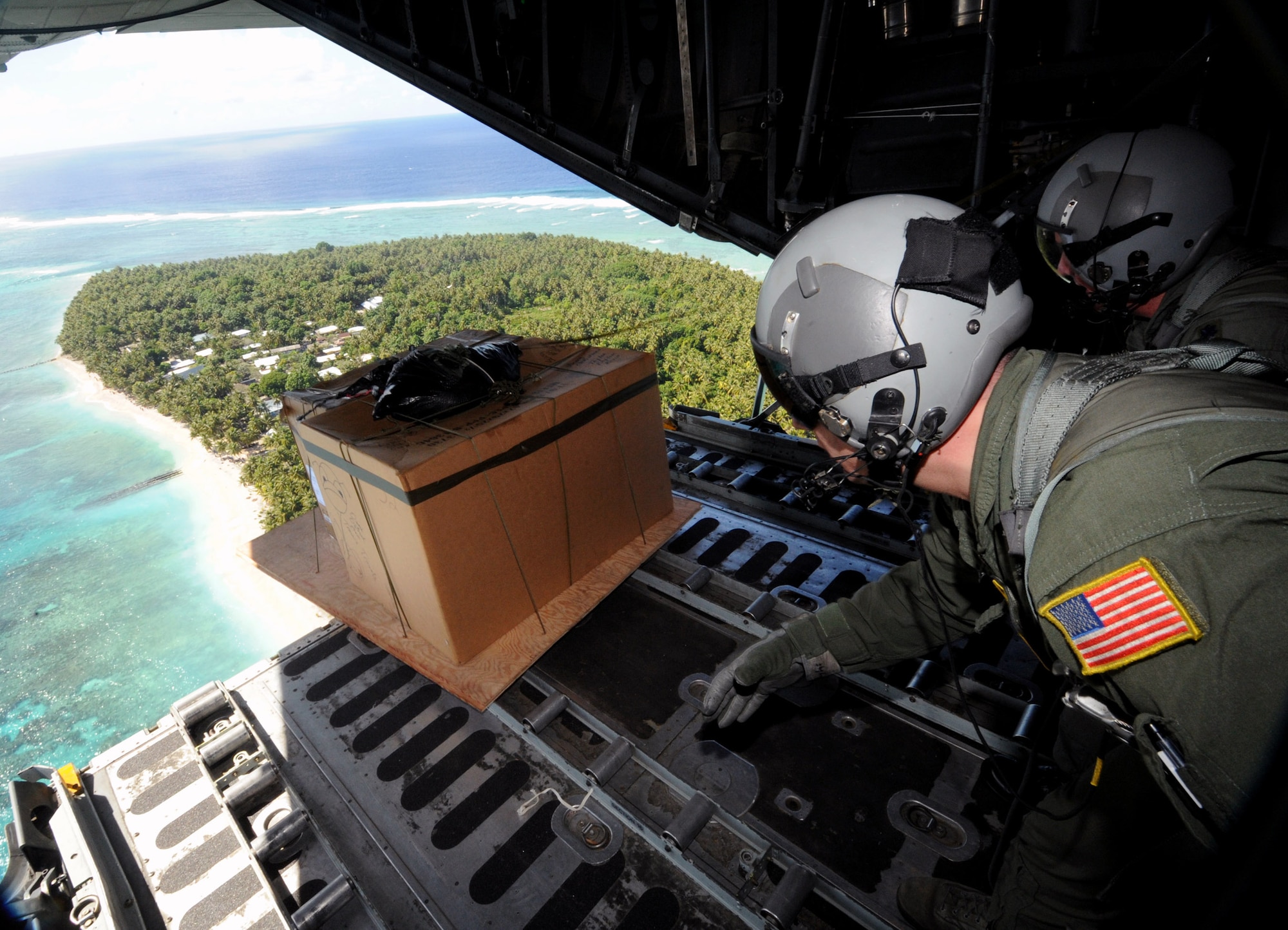 Tech. Sgt. Heath Bahyi and Chief Master Sgt. Michael Sundberg push out a boxed pallet of donated goods from a C-130 Hercules during Operation Christmas Drop Dec. 19 over the remote Island of Yap. Airmen today continue the tradition of delivering supplies to remote islands of the Commonwealth of the Northern Marianas Islands, Yap, Palau, Chuuk and Pohnpei. In all, more than 180 boxes were built for the humanitarian mission, making 2008 one of the largest drops in Operation Christmas Drop's 57-year history. Sergeant Bahyi and Chief Sundberg are loadmasters from the 36th Airlift Squadron from Yokota Air Base, Japan. (U.S. Air Force photo/Master Sgt. Kevin J. Gruenwald)