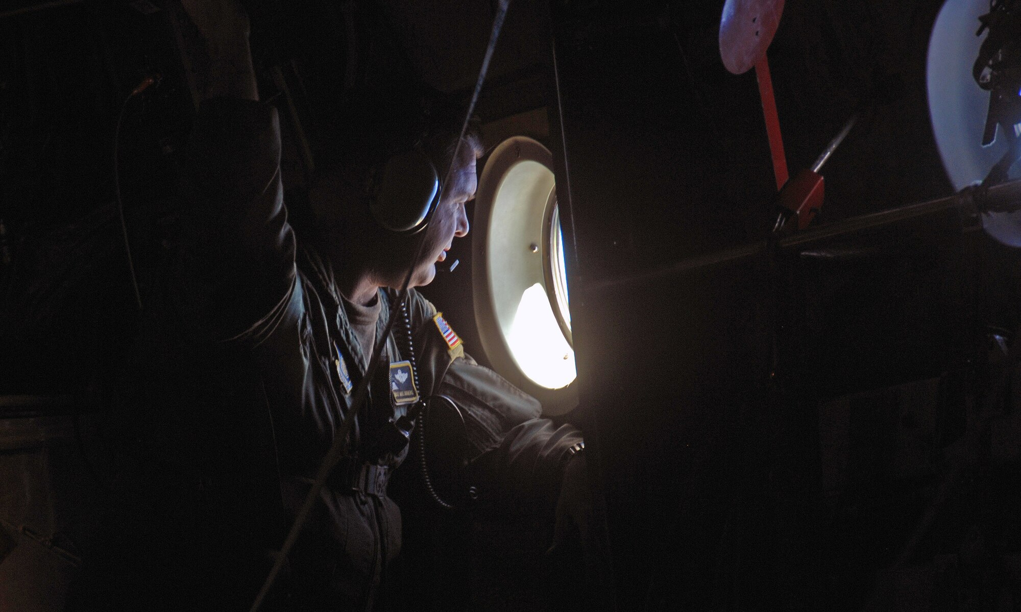 Chief Master Sgt. Michael Sundberg views a drop zone from a C-130 Hercules during Operation Christmas Drop Dec.19 over the Pacific Ocean. Airmen today continue the tradition of delivering supplies to remote islands of the Commonwealth of the Northern Marianas Islands, Yap, Palau, Chuuk and Pohnpei. More than 600 pounds of donated goods were dropped over the remote islands during Operation Christmas Drop. Chief Sundberg is a loadmaster from the 36th Airlift Squadron from Yokota Air Base, Japan.  (U.S. Air Force photo/Master Sgt. Kevin J. Gruenwald) 