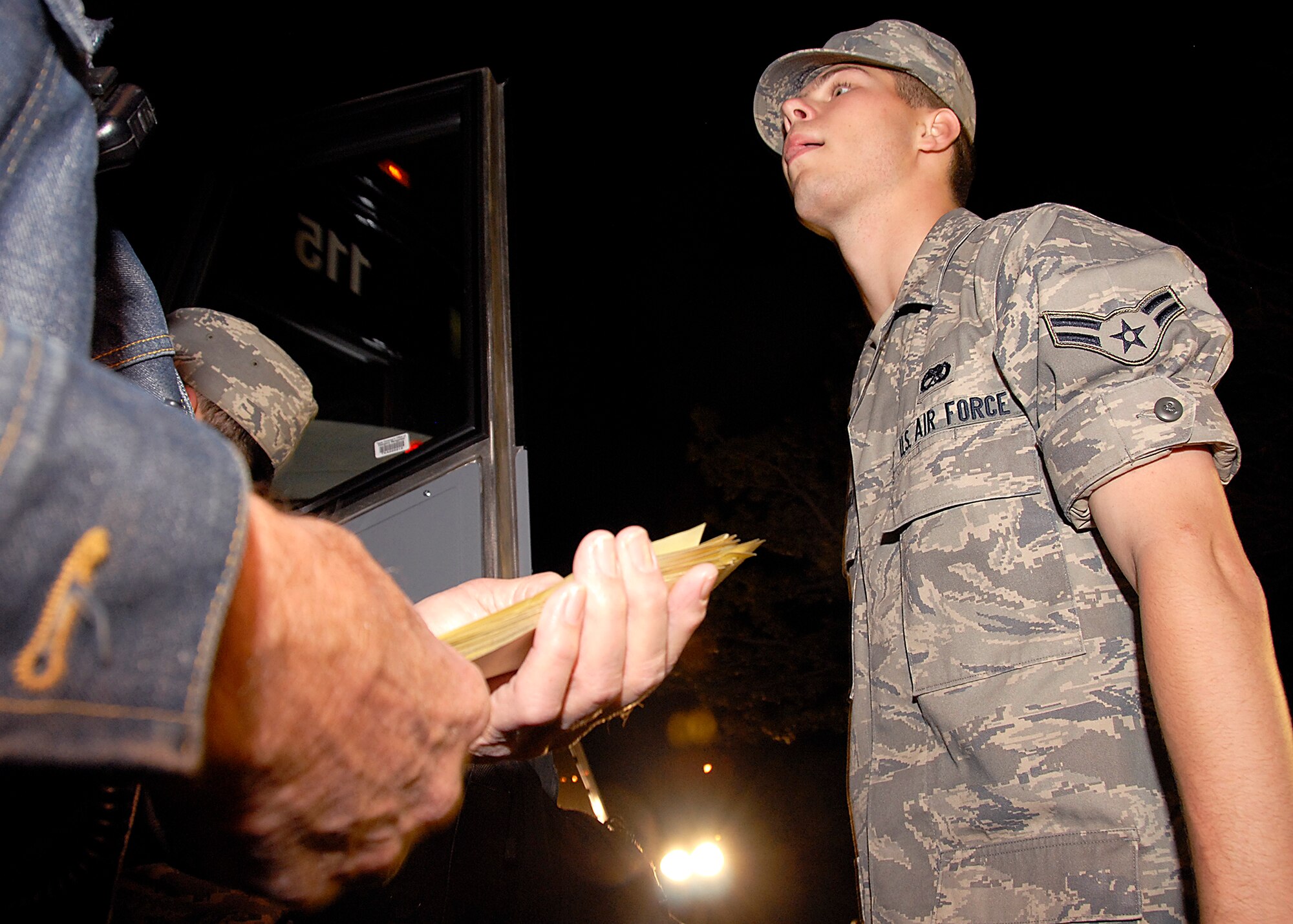 Airman 1st Class Thomas O'Connell from Newtonsville, Ohio waits his turn to board the bus, while the bus driver holds his tickets to go home for the holidays Dec. 19. About 4,000 Airmen went home for the holiday exodus and will return in early January to continue training Jan. 5. (U.S. Air Force photo/Harry Tonemah) 