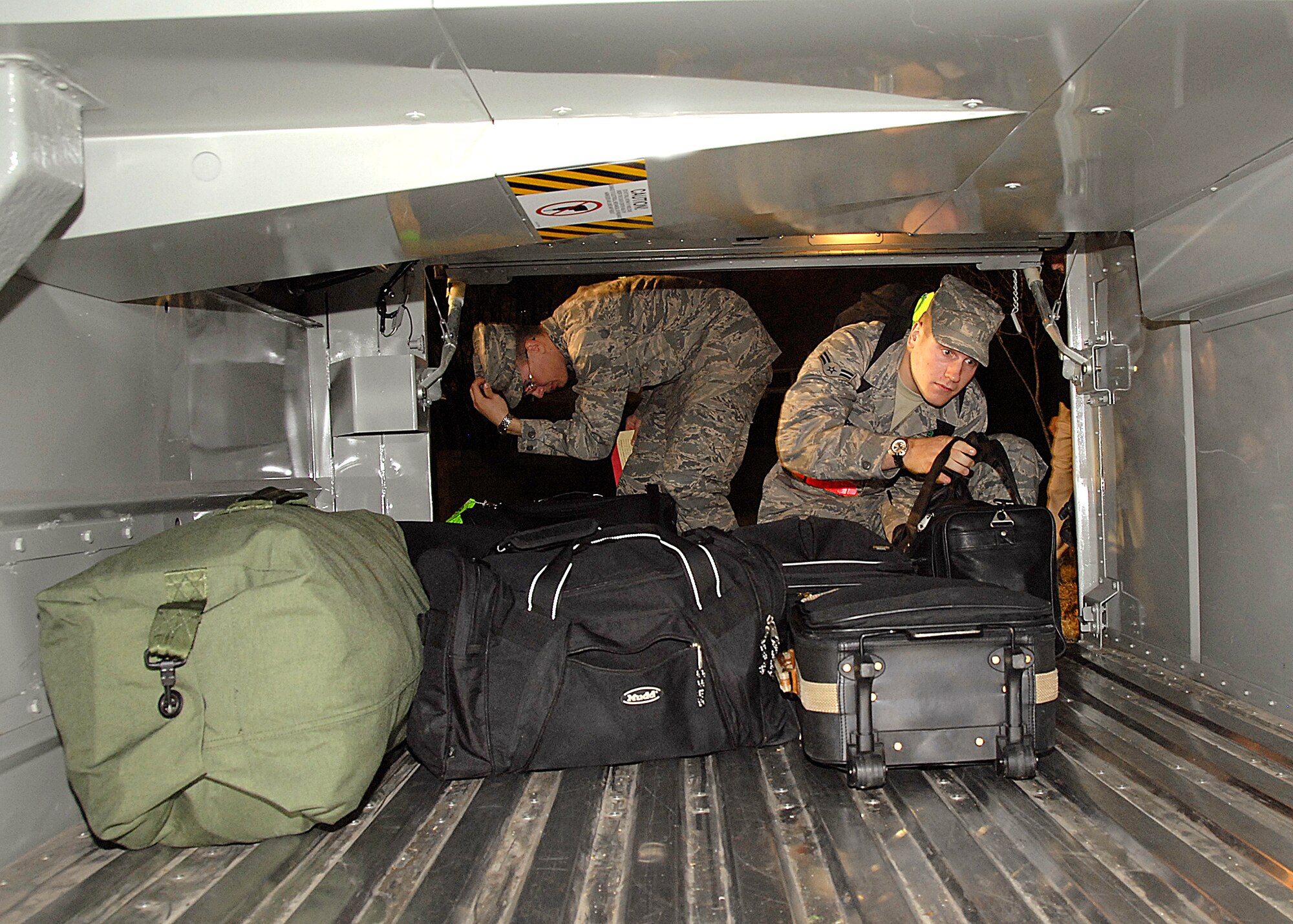 Two students stowe their luggage in the luggage compartment of the bus taking them to the airport to go home for the holidays Dec. 19. About 4,000 Airmen went home for the holiday exodus and will return in early January to continue training Jan. 5. (U.S. Air Force photo/Harry Tonemah) 