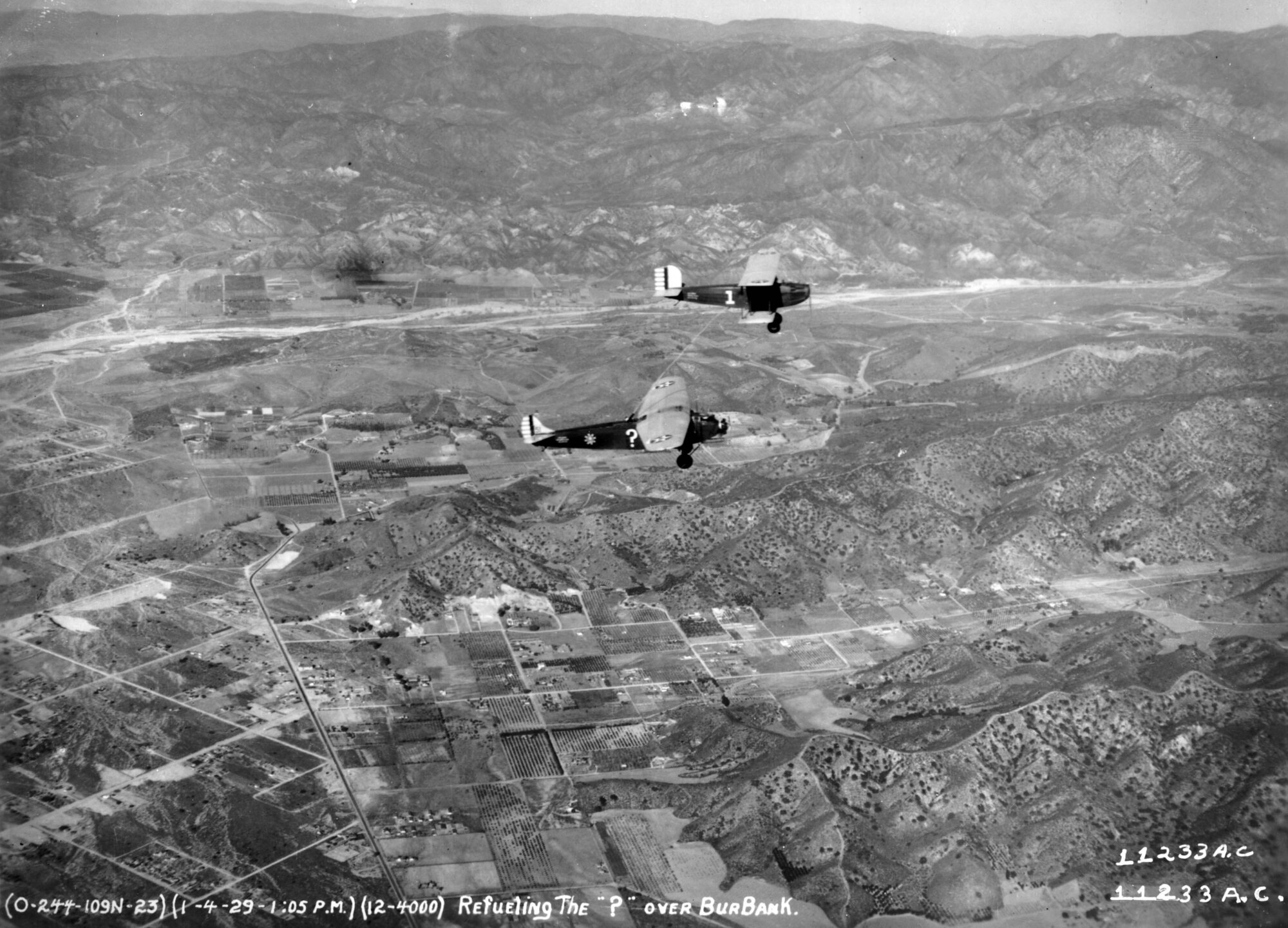 A Fokker C-2A is refueled in flight by a modified Douglas C-1 transport aircraft during an operation dubbed "Question Mark" in 1929. A large question mark was painted on each side of the receiver aircraft's fuselage, intended to "provoke wonder at how long the aircraft could remain airborne," according to Air Force historians. The Douglas C-1 aircraft were transformed into aerial refueling tankers by installing two 150-gallon tanks for offloading and a refueling hose that passed through a hatch cut in the floor of the aircraft. During the operation, which began on New Year's Day in 1929 and ended 150 hours and 40 minutes later on Jan. 7, the two Douglas refueling aircraft passed 5,660 gallons of fuel, completing 43 sorties, 12 of which occurred at night. (U.S. Air Force photo)
