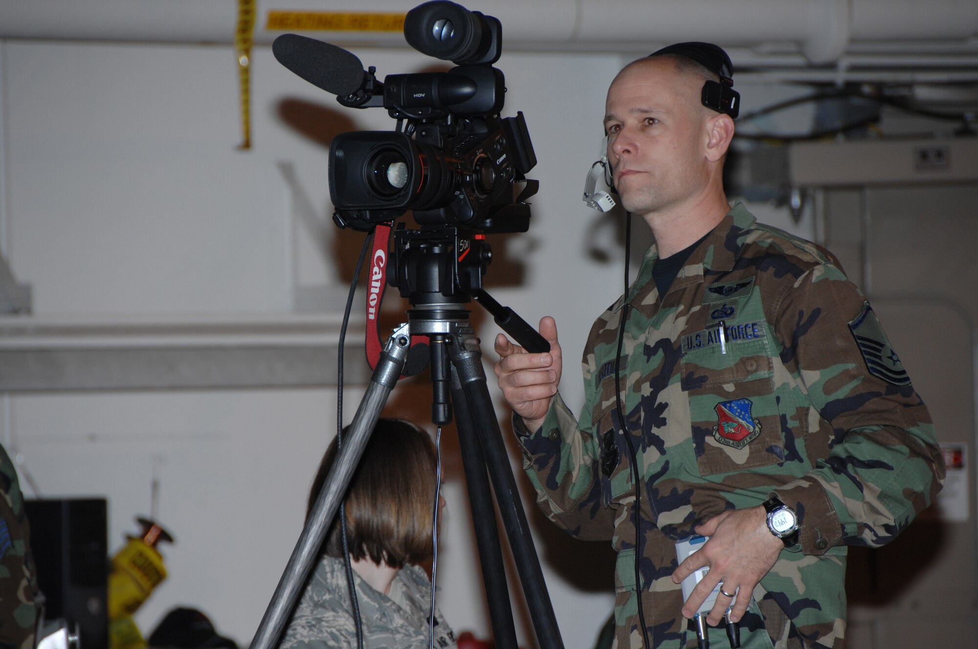 Tech. Sgt. Greg Wohlfeil, 133rd Communications Flight, operates one of the video cameras used to project images of presenters and award recipients onto two large screens for over 1,000 audience members in a hangar during the 133rd Airlift Wing Recognition Ceremony on Dec. 13, 2008. The Minnesota Air National Guard unit in St. Paul holds a ceremony every year recognizing the accomplishments of the Airmen, their families, and others in the community who make the 133rd AW very successful. . (USAF photo by Tech. Sgt. John Wiggins)