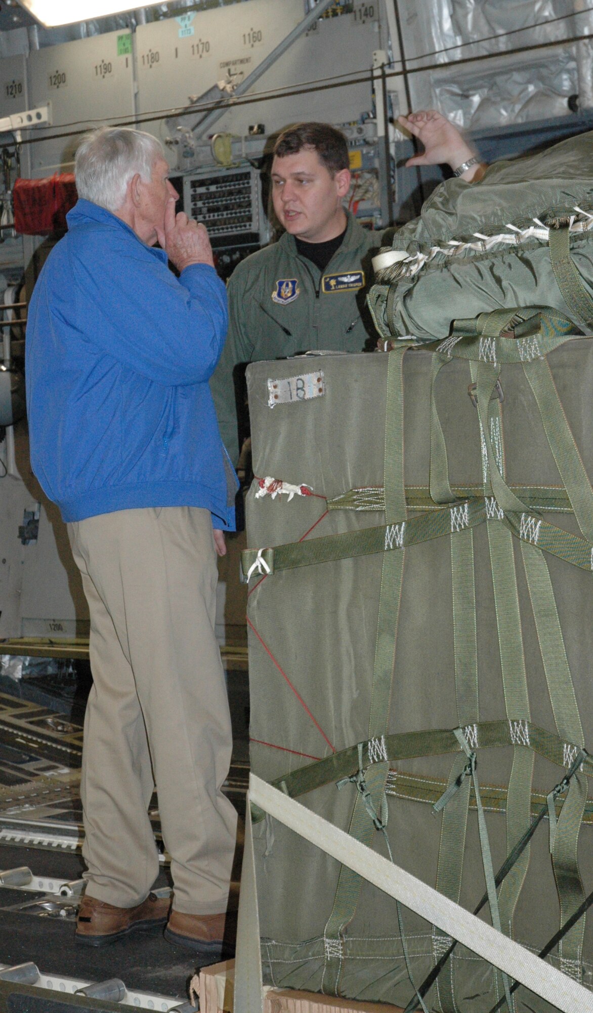 Major Don Thigpen, a pilot with the 317th Airlift Squadron, explains the capabilities of the C-17 Globemaster III to Bill Stancil, a pastor at Cathedral of Praise, during a 13 aircraft formation training mission on Dec 18. 