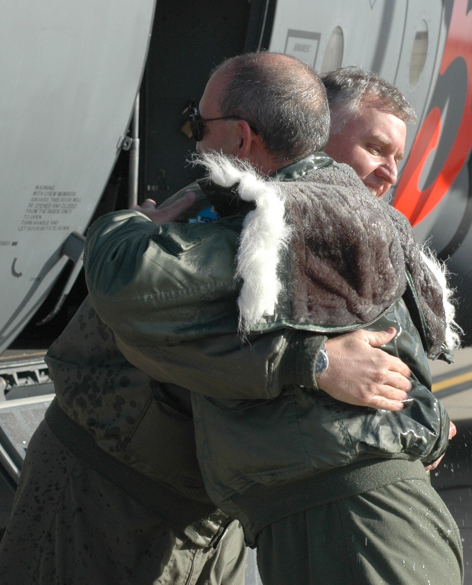 Lt. Col. Dan Mullins (left) hugs Col. James J. Muscatell, Jr., 302nd Airlift Wing commander after his final flight with the wing Dec. 22, 2008, at Peterson Air Force Base, Colo. Colonel Muscatell, commander of the airlift wing, performed his final flight before taking command of the 403rd AW at Keesler AFB, Miss., slated for mid-January 2009. Known as a "fine flight," a pilot is congratulated and recognized for their service to their squadron with a ceremonial gathering directly after the flight. Colonel Mullins is the 731st Airlift Squadron's chief pilot. (U.S. Air Force photo/Stephen J. Collier)