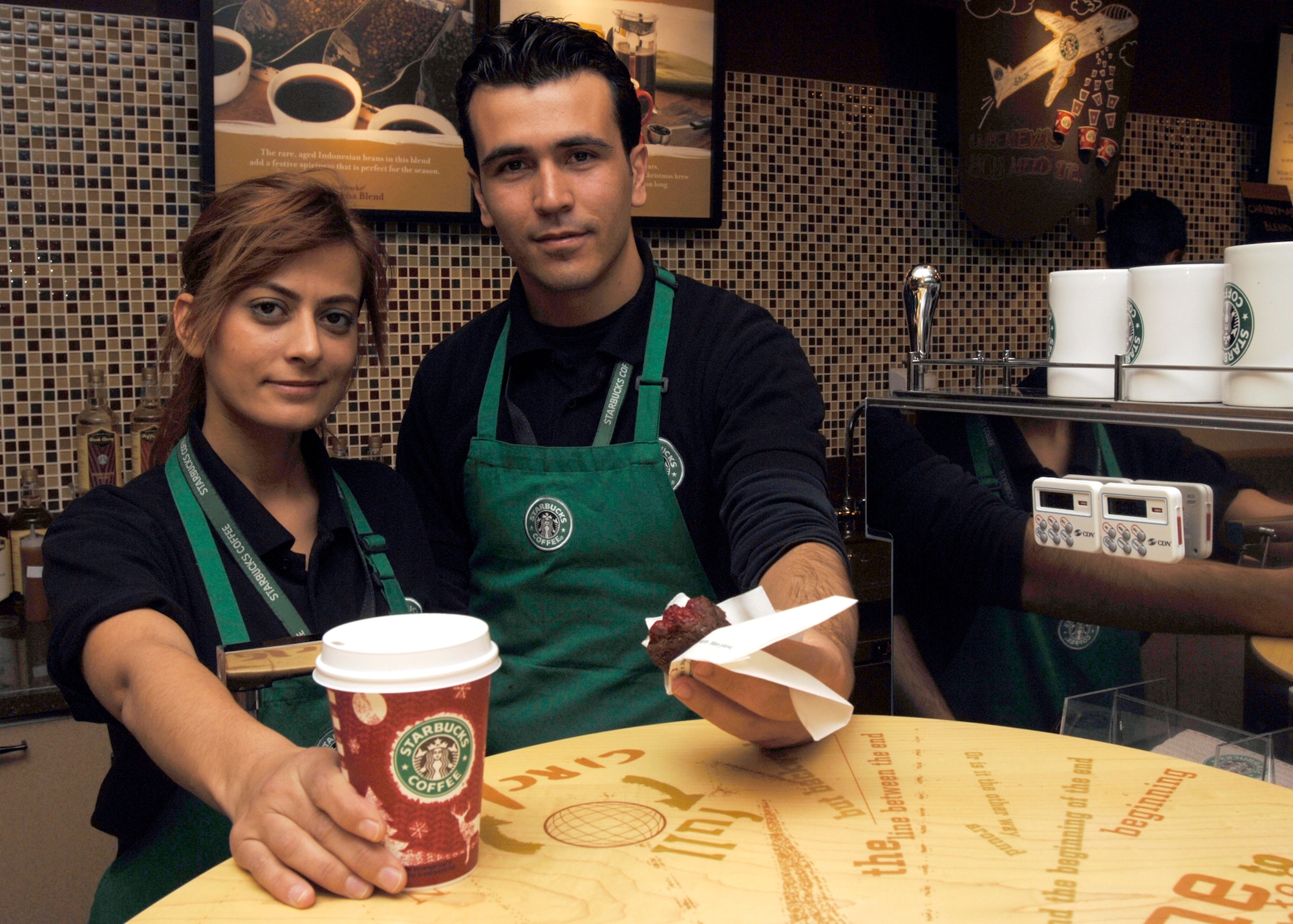 Serpil Tawcav, Incirlik Starbucks barista, and Serkan Tecir, Incirlik Starbucks shift supervisor, present Starbucks products during the "soft opening" of Starbucks at Incirlik Dec. 21. This is the first Starbucks in United States Air Forces Europe. (U.S. Air Force photo by Master Sgt. Edward Holzapfel)