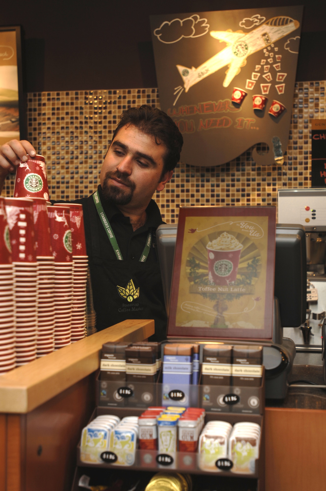 Ali Riza Nakis, Starbucks coffee master, stacks cups during the "soft opening" of Starbucks Coffee at Incirlik Air Base, Turkey, Dec 21. Certain base personnel were invited to attend this test run of the first Starbucks in United States Air Forces Europe. (U.S. Air Force photo illustration by Master Sgt. Edward Holzapfel)