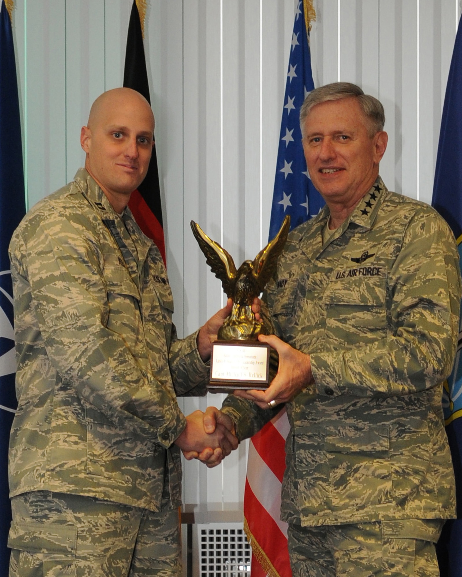 Gen. Rodger Brady, Allied Air Component Command Headquarters and U.S. Air Forces in Europe commander, presents the Air Force Element NATO Allied Command Operations SIJAN award to Capt. Michael Rellick during a ceremony at Ramstein Air Base, Dec. 17, 2009. Captain Rellick earned the award for outstanding leadership demonstrated at NATO and while deployed to Afghanistan. (U.S. Air Force photo by Airman 1st Class Caleb Pierce)