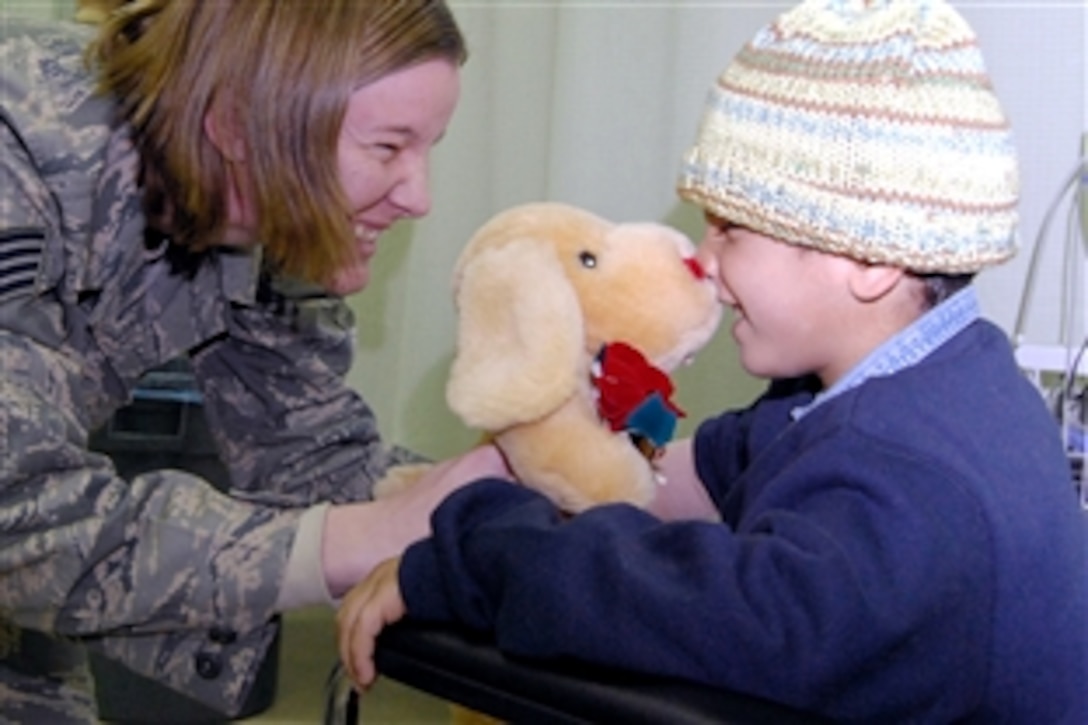 U.S. Air Force Staff Sgt. Renee Durbin holds a stuffed animal up to Mustafa Jasim's nose in the Air Force Theater Hospital's intermediate care ward at Joint Base Balad, Iraq, Dec. 20, 2008. Mustafa, his brother and an Iraqi police officer were transported from Balad to the 86th Combat Support Hospital in Baghdad. Durbin, a volunteer with the hospital's Patient Administration and Disposition area, is deployed with the 332nd Expeditionary Maintenance Group.