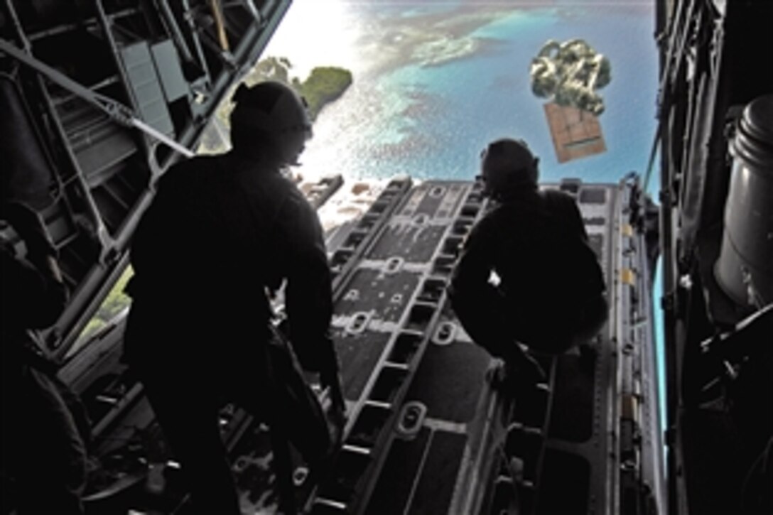 U.S. Air Force Senior Airman Robert Gore and Airman 1st Class Dustin Deveaux push out a pallet of donated goods from a C-130 Hercules over the Pacific islands of Chuuk, Dec. 19, 2008. Gore and Deveaux, assigned to the 36th Airlift Squadron from Yokota Air Base, Japan, continue the Air Force tradition of delivering supplies to remote islands of the Commonwealth of the Northern Marianas Islands, Yap, Palau, Chuuk and Pohnpei.