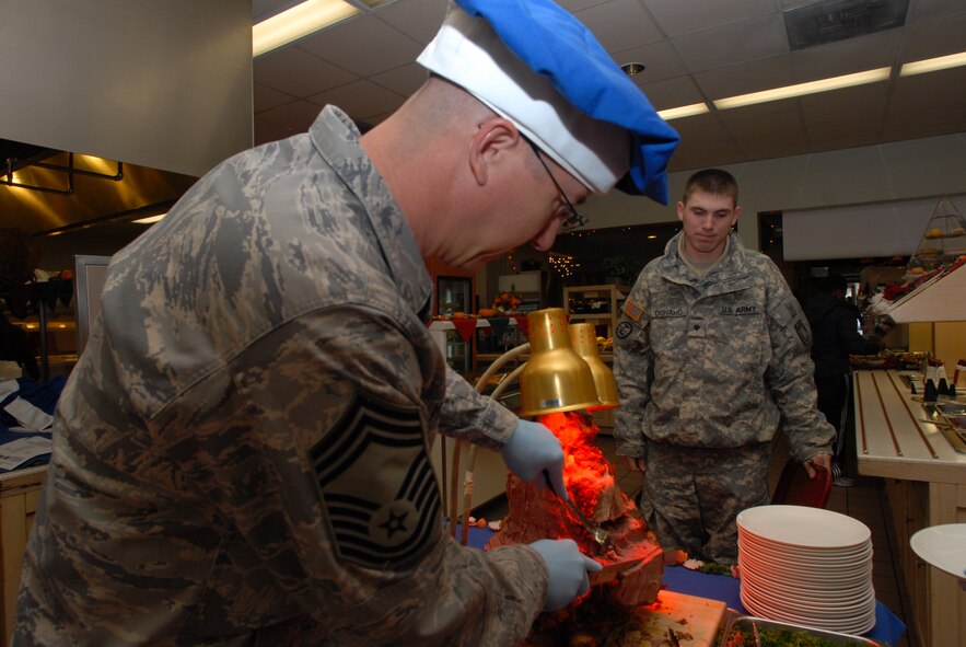 KUNSAN AIR BASE, Republic of Korea -- Chief Master Sgt. Michael Mezick, 8th Communications Squadron, serves Christmas lunch to Kunsan Airmen and Soldiers, Dec. 25, 2008. A holiday tradition around the Air Force, wing leadership switched places with dining facility staff and served lunch to Wolf Pack members. (Photo by Senior Airman Angela Ruiz)