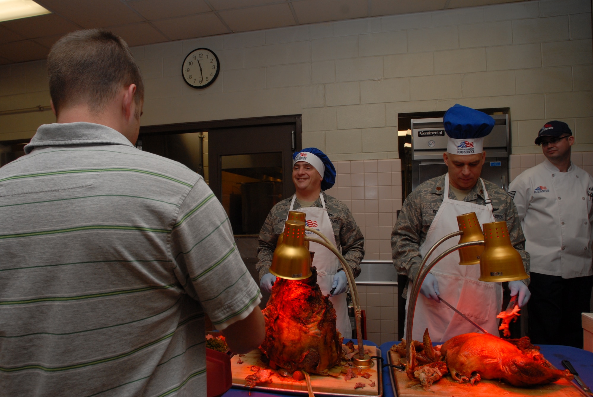 KUNSAN AIR BASE, Republic of Korea -- Lt. Col. Peter Sartori, 8th Mission Support Group deputy commander, and Chap. (Maj.) John Kenyon, 8th Fighter Wing chaplain, serve Christmas lunch to Kunsan Airmen and Soldiers, Dec. 25, 2008. A holiday tradition around the Air Force, wing leadership switched places with dining facility staff and served lunch to Wolf Pack members. (Photo by Senior Airman Angela Ruiz)
