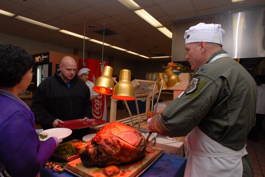 KUNSAN AIR BASE, Republic of Korea -- Col. J. D. "Wolf" Harris, 8th Fighter Wing commander, serves Christmas lunch to Kunsan Airmen and Soldiers, Dec. 25, 2008. A holiday tradition around the Air Force, wing leadership switched places with dining facility staff and served lunch to Wolf Pack members. (Photo by Senior Airman Angela Ruiz)