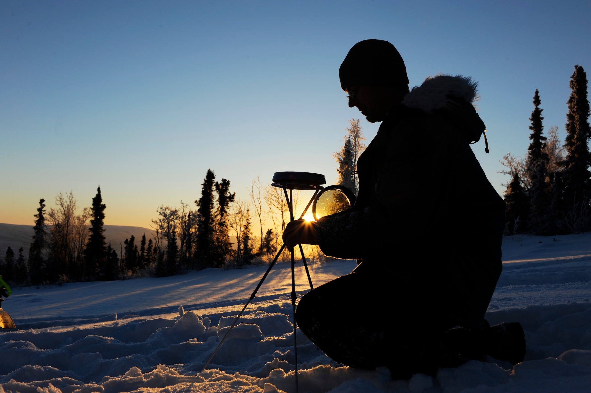 Staff Sgt. Stewart Raring adjusts the solar pathfinder to see an accurate reading Dec. 16, 2008, at a remote operating facility in the Interior of Alaska. A solar pathfinder shows the year-round, site-specific solar data to determine the best location and angle to setup solar panels. Currently Detachment 460 plans on constructing a solar hybrid power system at seven different locations replacing their current propane power source saving more than $100,000 in maintenance and refueling over a five year period. He is assigned to Det. 460 at Eielson Air Force Base, Alaska.  (U.S. Air Force photo/Senior Airman Jonathan Snyder)