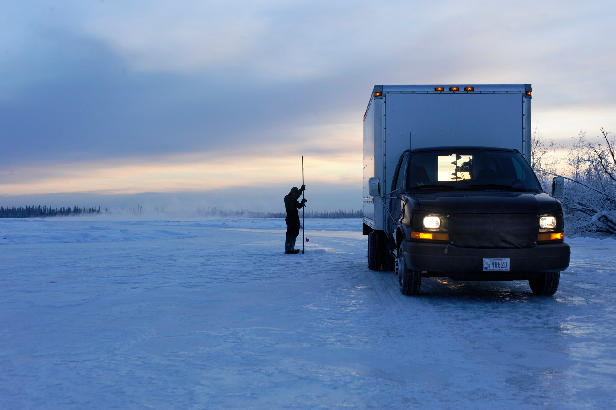 Airman 1st Class Alexandre Leseur measures the thickness of the ice to determine how close they are to their 60 inch of ice thickness goal Dec. 23, 2008, Fairbanks, Alaska. The ice bridge takes six to 10 weeks to complete in sub-zero weather. The ice bridge is actually a series of ice plateaus five-feet deep, 32 miles long and capable of supporting more than 110 tons -- and will melt back into the river as spring thaw hits. Airman Leseur is assigned to the 354th Civil Engineer Squadron range maintenance, Eielson Air Force Base, Alaska.  (U.S. Air Force photo/Senior Airman Jonathan Snyder)