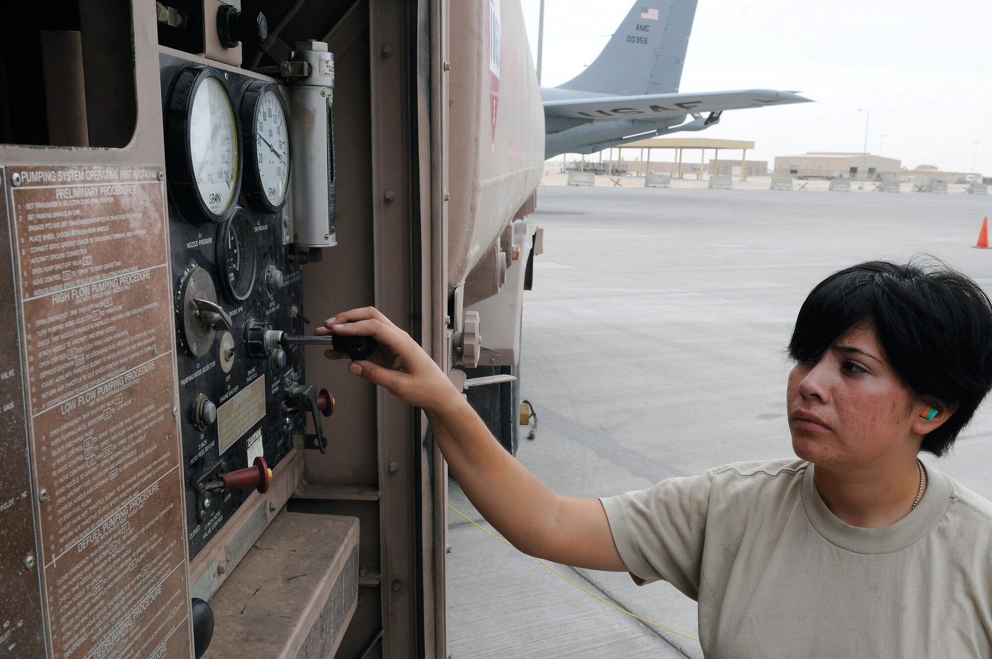 Airman 1st Class Angelica Gonzalez slows down the flow of fuel at an air base in Southwest Asia. She carefully controls the speed of fuel leaving her fuel truck and entering a KC-135 Stratotanker. Depending on the mission the KC-135 can hold four or five fuel trucks worth of fuel. Airman Gonzalez is a fuels apprentice assigned to the 379th Expeditionary Logistics Readiness Squadron. She is a native of Scotts Bluff, Neb., and deployed from Kadena Air Base, Japan. (U.S. Air Force photo/Tech. Sgt. Michael Boquette) 
