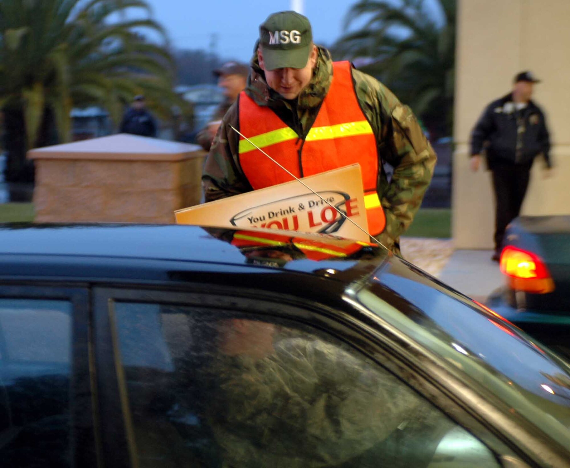 Chief Master Sgt. Joseph Mangum, 60th Mission Support Group superintendant, reminds a Travis Airman to keep safety a top priority this holiday season, during a safety checkpoint at the Main Gate Dec. 24. (U.S. Air Force photo/Airman 1st Class Kristen Rohrer)