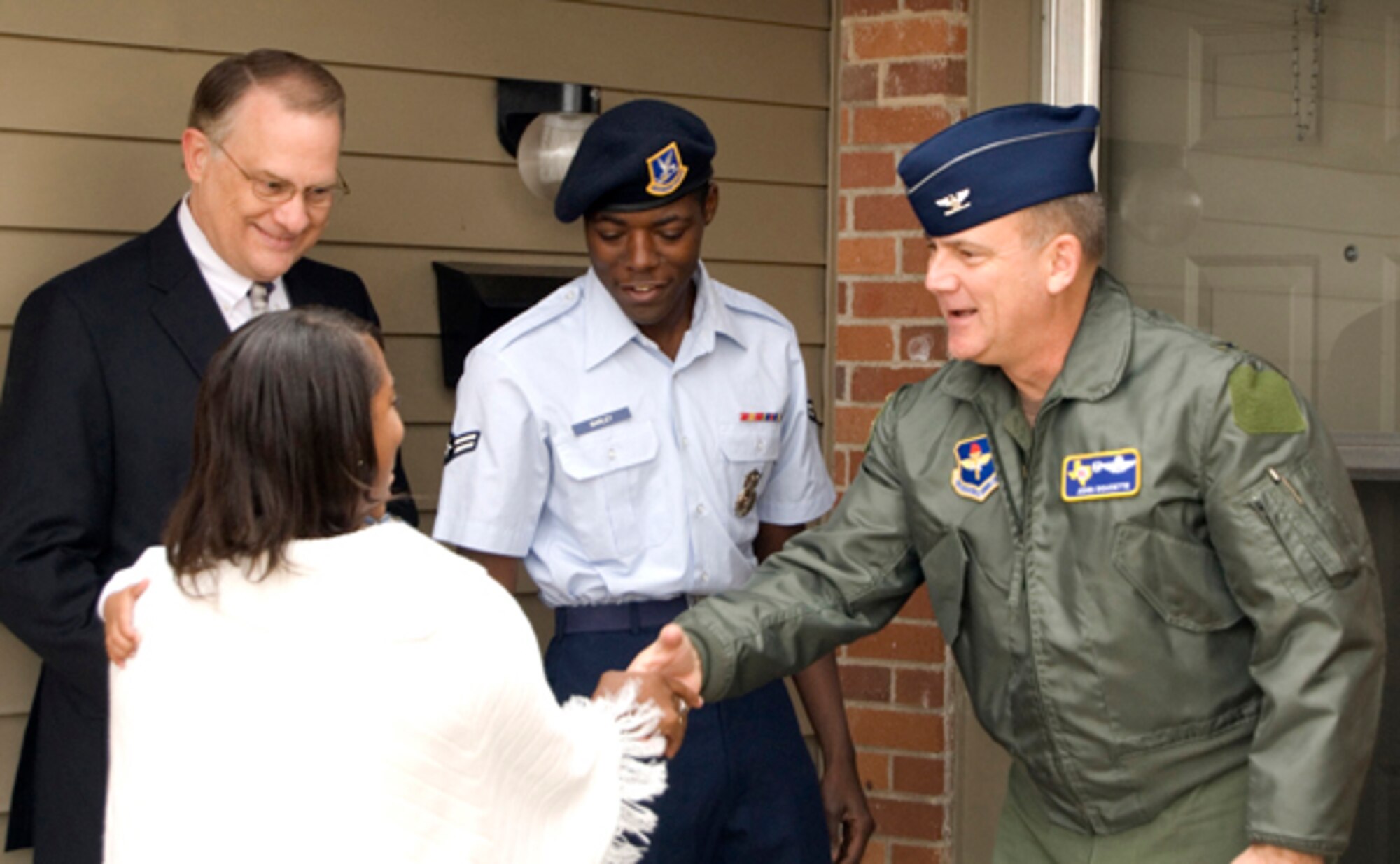 LAUGHLIN AIR FORCE BASE, Texas – Col. John Doucette, 47th Flying Training Wing commander, welcomes Airman 1st Class Remario Barley, 47th Security Forces Squadron, and his family to their new home and the very first fully renovated military family housing unit here recently. The new home is one of 450 units on base that will be fully renovated in effort to provide a better quality of life for Laughlin members. (U.S. Air Force photo by Charlena Cavender)   