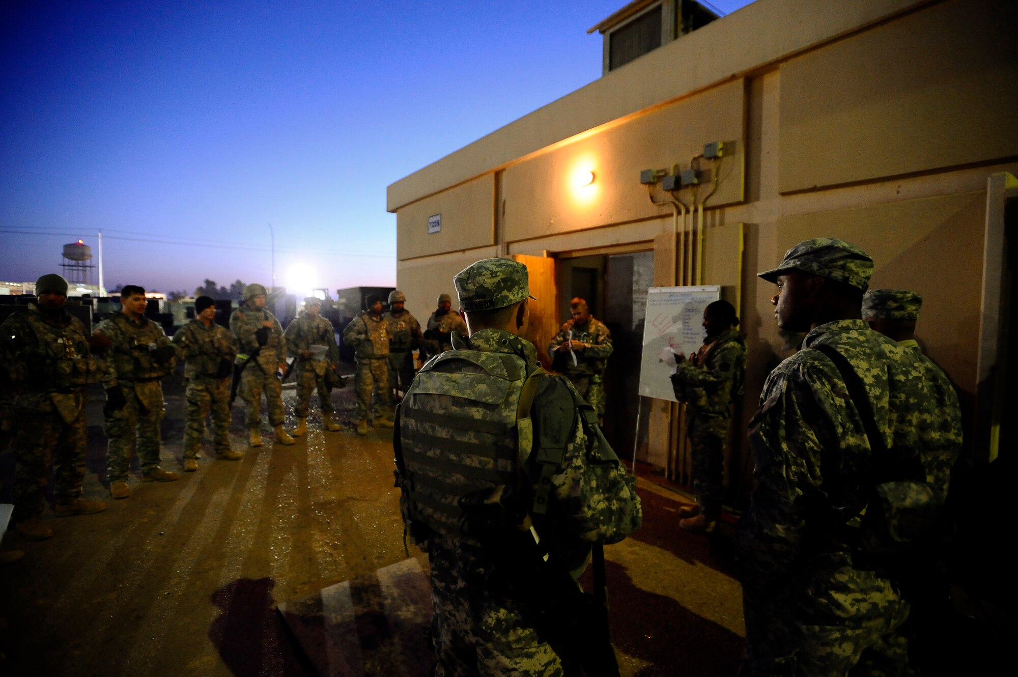 Airmen and Soldiers gather for a briefing prior to an outside-the-wire mission Dec. 11 at Joint Base Balad, Iraq. The Airmen, who are assigned to the 732nd Expeditionary Civil Engineer Squadron Det. 6, undertake construction projects for the Army, while the Soldiers provide convoy security. (U.S. Air Force photo/Airman 1st Class Jason Epley) 
