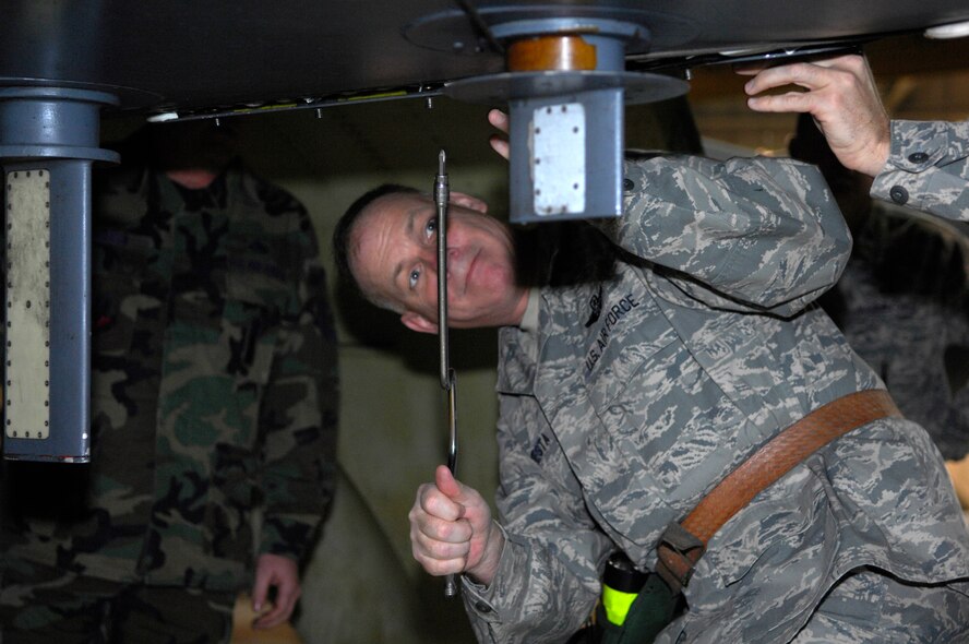 MINOT AIR FORCE BASE, N.D. -- Col. Joel Westa, 5th Bomb Wing commander, loosens a panel on a B-52H Stratofortress while participating in a missile load here Dec. 23. The loading event gave the commanders a chance to see what obstacles missile loaders must overcome to make the mission a success. Several other 5th BW commanders also participated in the missile loading. (U.S. Air Force photo by Senior Airman Joe Rivera)