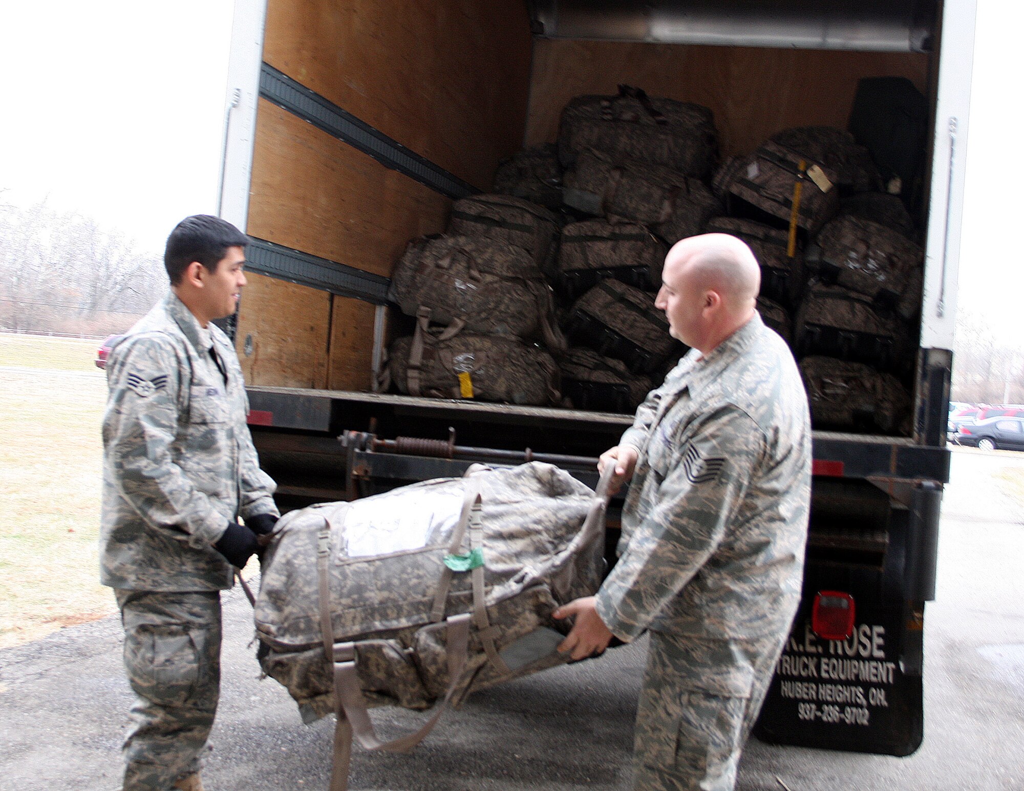 WRIGHT-PATTERSON AFB, Ohio - Tech. Sgt. Khristopher Powell and Senior Airman Justavo Medina, both with the 445th Security Forces Squadron, load their bags onto a truck Dec. 20, 2008 before leaving for a six month deployment to Southwest Asia.  The 445th Security Forces Squadron had 18 members deploy in December. (Air Force photo/Maj. Cynthia Harris) 