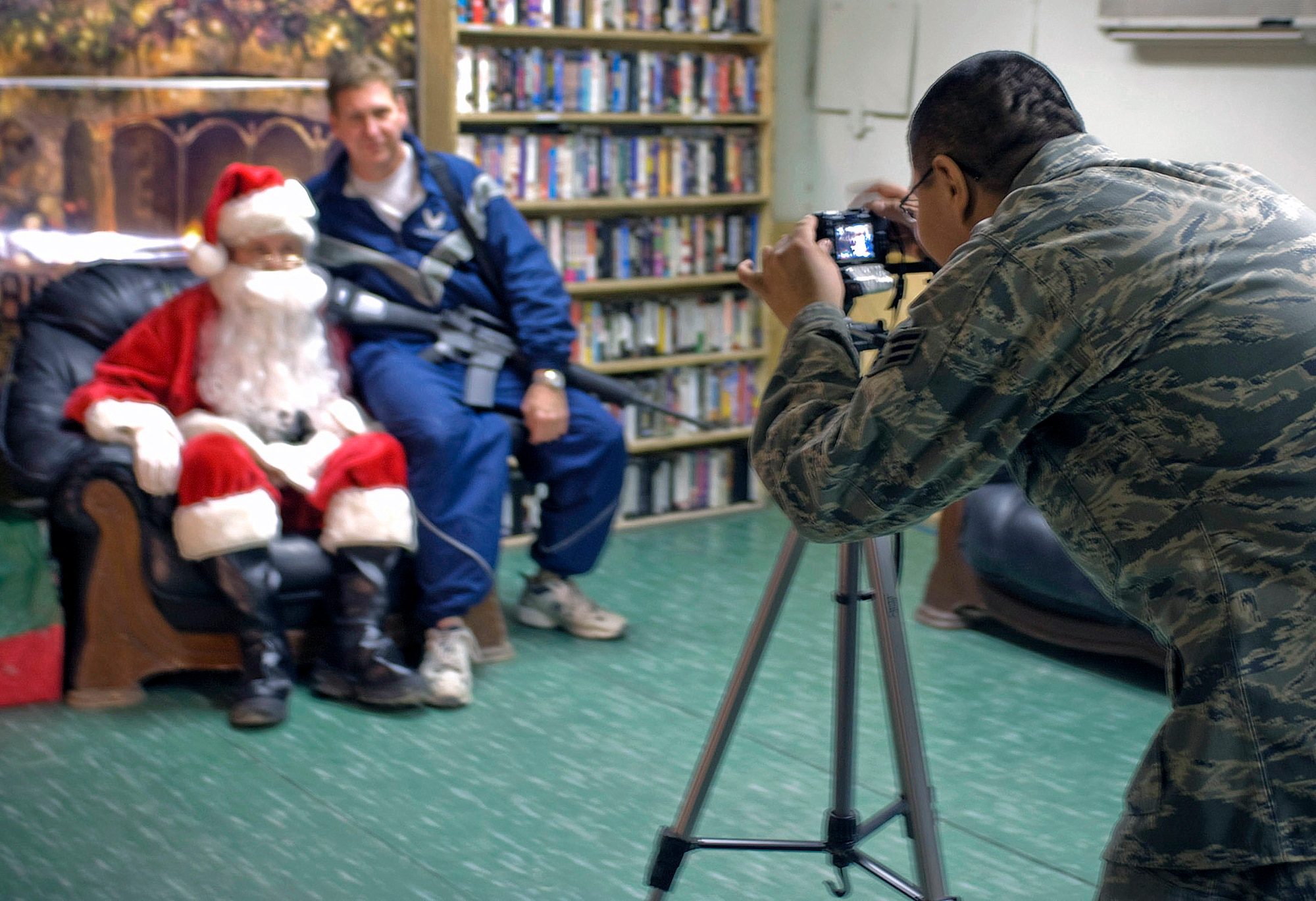 Senior Airman Marco Palacios takes an Airman's photo with Santa Claus Dec. 17 at Bagram Airfield, Afghanistan. Airman Palacios, from Reno, Nev., took nearly 300 pictures for Airmen and turned them into e-cards they could send to their family and friends. Airman Palacios is a services technician with the 455th Expeditionary Force Support Squadron. (U.S. Air Force photo/Staff Sgt. Rachel Martinez) 
