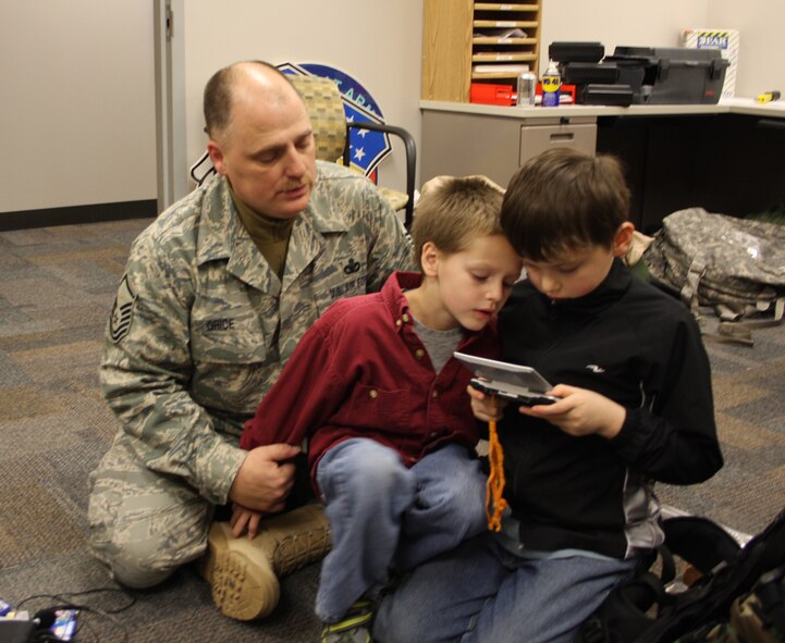 WRIGHT-PATTERSON AFB, Ohio - Master Sgt. John Grice, 445th Security Forces Squadron, spends a few moments playing video games with his sons, Ryeley and Devin, Dec. 20, 2008, before leaving for his six month deployment to Southwest Asia.  The 445th Security Forces Squadron had 18 members deploy in December. (Air Force photo/Maj. Cynthia Harris) 
