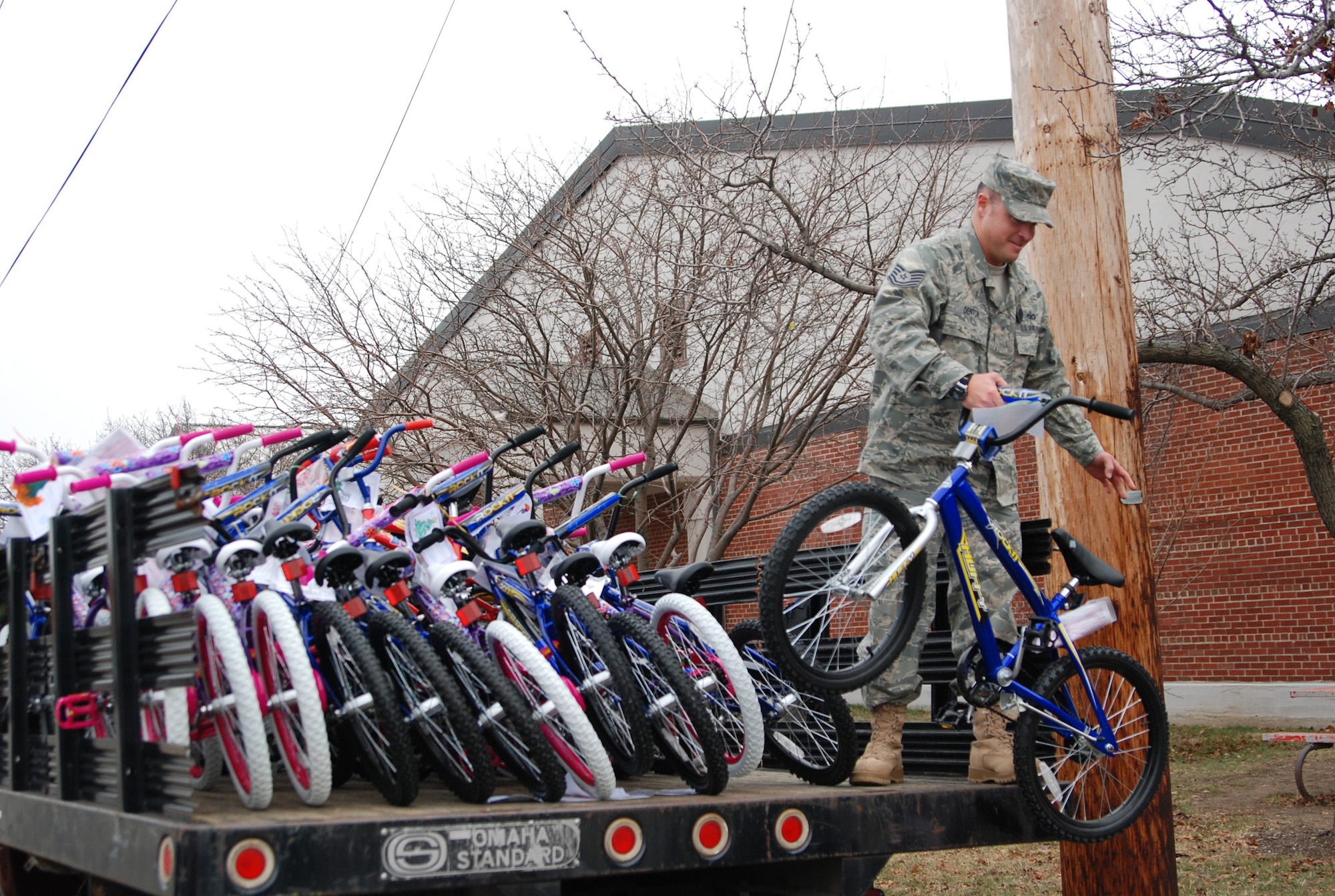 WRIGHT-PATTERSON AFB, Ohio - Tech. Sgt. Paul Denton, 445th Security Forces Squadron, unloads bicycles donated by the Reynolds and Reynolds Co. Dec. 16, 2008.  The company, headquartered in Dayton, Ohio, gave 101 children's bicycles to Wright-Patterson's younger dependents.  Reynolds and Reynolds employees and family members assembled the bicycles after the company Christmas party.  The bikes were gifts to Air Force families to help offset rising costs, especially for those who are deployed. (Courtesy photo) 