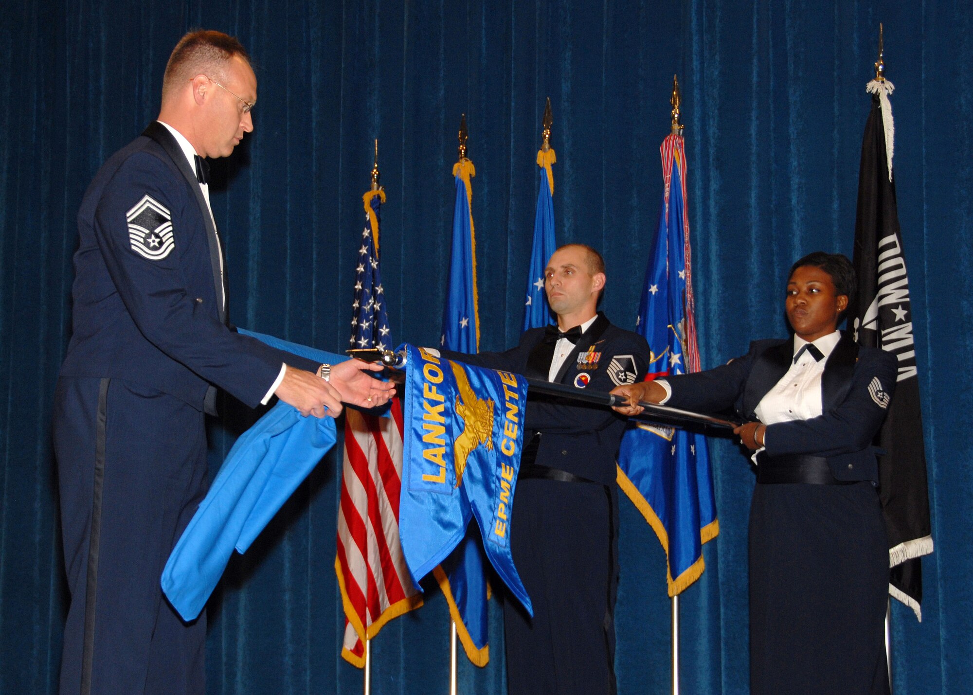 Air National Guard members Senior Master Sgt. Timothy J. Kumes, Master Sgt. Paul G. Rayman, and Tech. Sgt. Jeela S. Matthews perform a guidon exchange ceremony at The I. G. Brown Air National Guard Training and Education Center to signify the transition of the ANG EPME branch to its new name as the Paul H. Lankford Enlisted Professional Military Education Center December 16, 2008. (U.S. Air Force Photo by Master Sgt Kurt Skoglund)(Released)