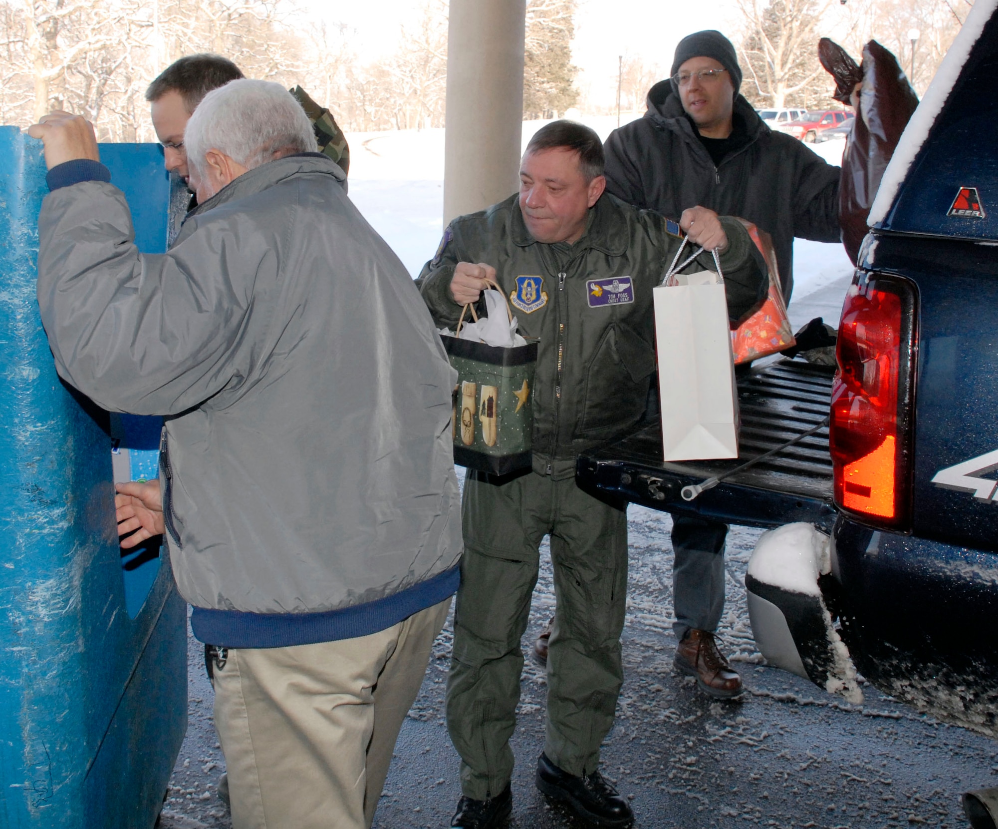 From left, 934th members Tom Alber, Master Sgt. Chris Neitzel, Chief Master Sgt. Tom Foss, and Senior Master Sgt. Mike McGuire unload gifts at the Minnesota Veterans Home Dec. 17.  The gifts, donated by 934th AW members, are given to residents of the home as part of the annual Adopt a Vet program sponsored by the wing. (Air Force Photo/Master Sgt. Paul Zadach) 