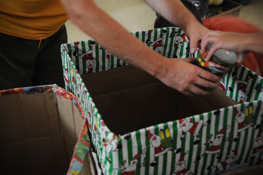 Air Force members from 506th Expeditionary Air Refueling Squadron sort canned goods and Christmas gifts at the Salvation Army on Guam, Christmas Eve Dec. 24. The canned goods and gifts will be handed out on Christmas Day to local families. The 506th EARS is deployed from the 171st Air Refueling Wing, Pittsburg, Pa. to Andersen Air Force Base in support of Pacific refueling operations. (U.S. Air Force photo/ Master Sgt. Kevin J. Gruenwald) released   .(U.S. Air Force photo/ Master Sgt. Kevin J. Gruenwald) released   