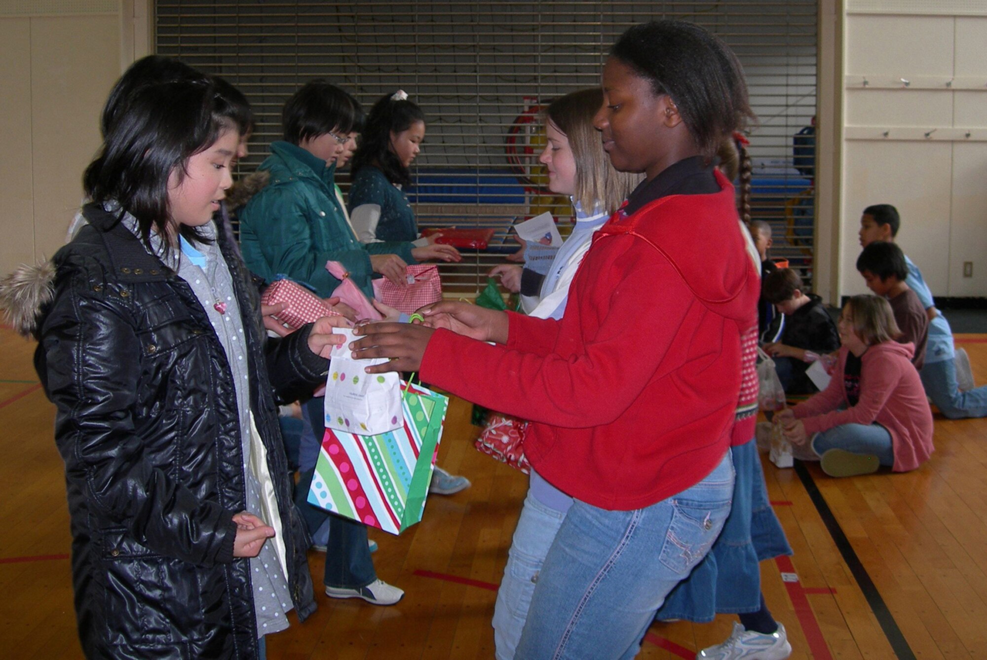MISAWA AIR BASE, Japan -- Yuko Nakamura, Kinoshita Elementary School, and Mia Orange, Cummings Elementary School, exchange presents during the 16th Annual Oirase Town and Misawa Air Base sixth-grade Children's Cultural Exchange Christmas party Dec. 6, 2008. (Courtesy photo by Simon Bernard)