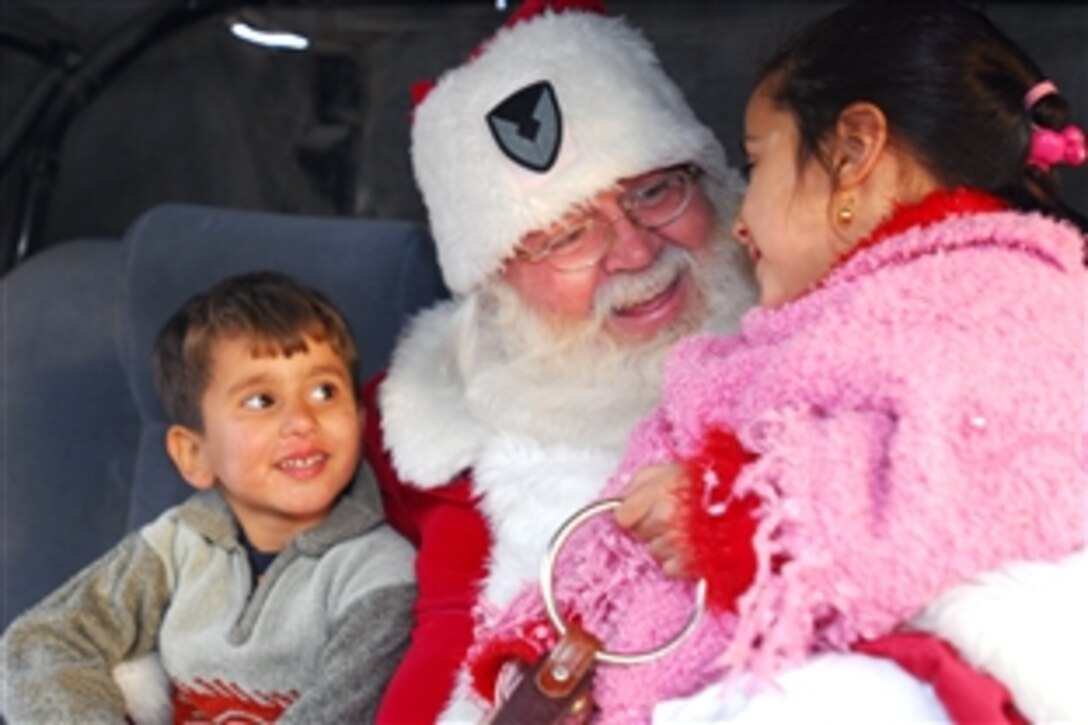 Iraqi scouts get a visit from Santa Claus, played by civilian contractor Joseph Lord, during a holiday-themed scouting event on Victory Base Complex, Dec. 20, 2008. The Victory Base Council is a group of volunteers who work to help local Iraqis build a Boys and Girl Scouts program of their own. They hold weekly scouting events which include sing-alongs, crafts, sports and team-building events.