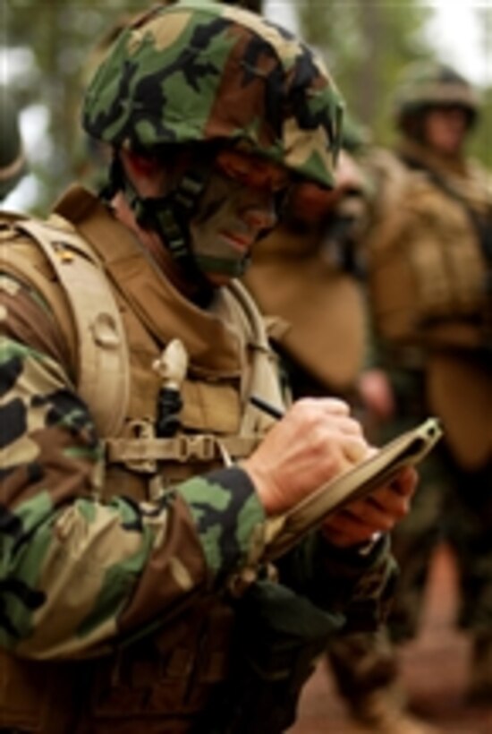 U.S. Navy Ensign Dennis Lang, assigned to Naval Mobile Construction Battalion 74, writes out instructions for a patrol during a training exercise at Camp Shelby, Miss., on Dec. 17, 2008.  Naval Mobile Construction Battalion 74 chiefs and officers are conducting a weeklong field exercise to train for contingency operations in a field environment.  