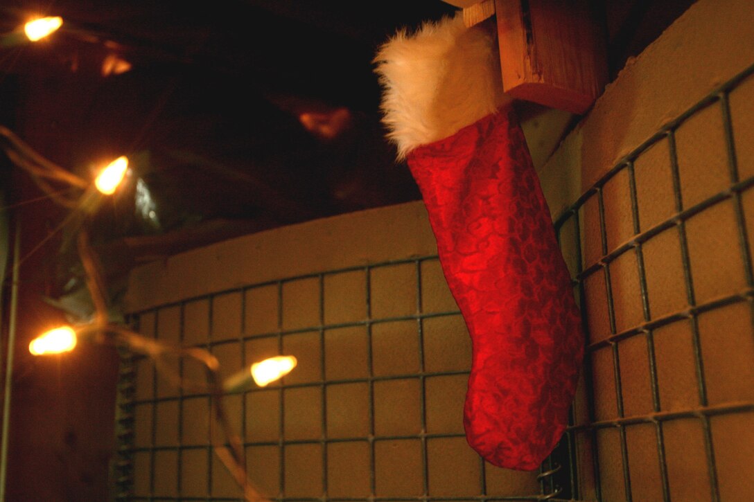 A Christmas stocking hangs by a string of lights on barrier walls at that protect the living areas of Marines with Task Force 3rd Batalion, 7th Marine Regiment, Regimental Combat Team 5 at Combat Outpost Ubaydi, Iraq, Dec. 25.  Ornamented trees, stockings and holiday signs adorned offices and living areas at the combat outpost as Marines celebrated the holiday season.::r::::n::