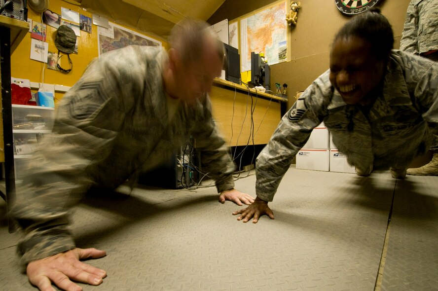 U.S. Air Forces Central Command Chief Master Sgt. Scott Dearduff performs pushups with Master Sgt. Annette Williams, 455th Air Expeditionary Wing Equal Opportunity director, at Bagram Air Field, Afghanistan, Christmas Eve, Dec. 24. Chief Dearduff encouraged the pushups from Sergeant Williams, deployed from the U.S. Air Force Academy, Colo., to give her a taste of home. The commander of the 10th Air Base Wing at the academy has a reputation for encouraging morale-building pushups like this. (U.S. Air Force photo by Staff Sgt. Samuel Morse)(Released)