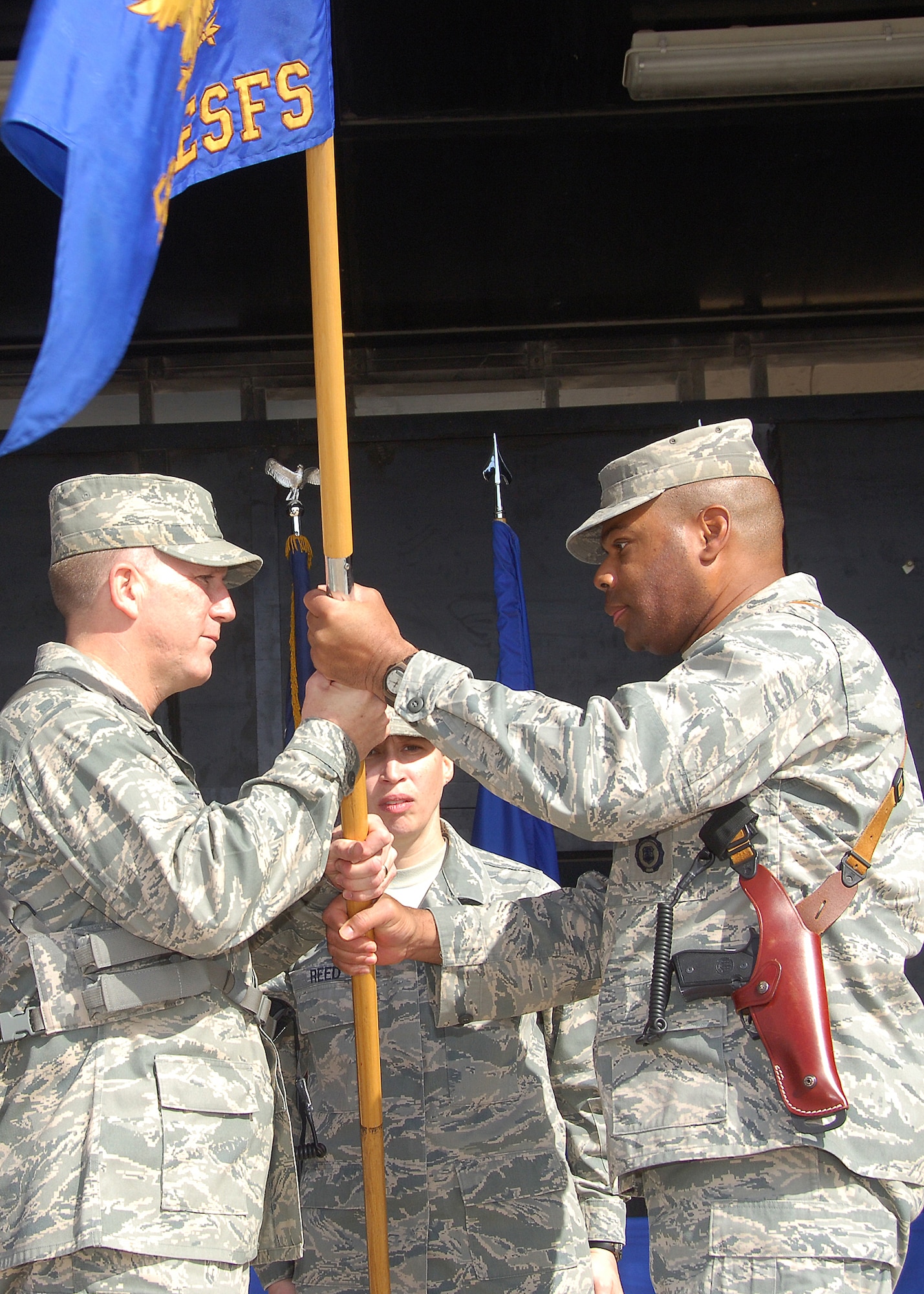 CAMP BUCCA, IRAQ -- Lt. Col. Bruce Watson, right, 586th Expeditionary Security Forces Squadron commander, relinquishes command of the 586th ESFS to Col. Alan Metzler, 586th Air Expeditionary Group commander, during the inactivation ceremony on Dec. 22. During its tenure, the 586th ESFS provided detainee operations and forward operating base defense, and conducted area security operations while providing convoy security for almost four years. The different mission sets of the 586th ESFS will now be handled by the 887th ESFS and Ugandan military members.  (U.S. Air Force photo/Tech. Sgt. Raheem Moore)