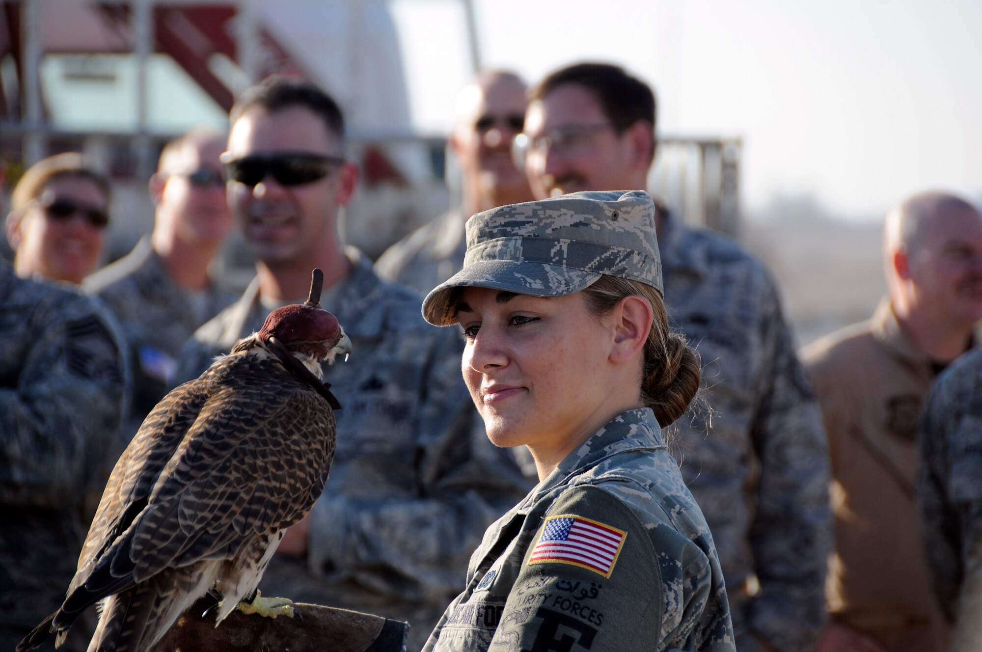 Senior Airman Brittany Schmid, a security forces journeyman assigned to the 379th Expeditionary Security Forces Squadron, has an up close and personal experience with a trained hunting falcon, Dec. 23, at an undisclosed air base in Southwest Asia. The host nation treated military members to an Arabian Night, featuring falcons, camel riding, a traditional meal, and henna hand decorations available for the female members.  Airman Schmid is deployed in support of Operations Iraqi and Enduring Freedom and Joint Task Force-Horn of Africa. (U.S. Air Force photo by Tech. Sgt. Michael Boquette/Released)