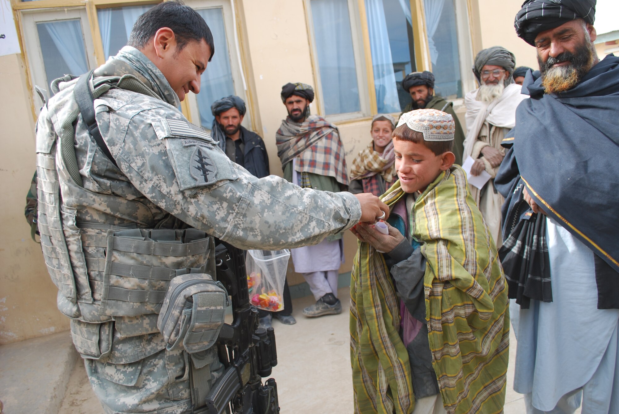 Army Sgt. Jose Estrada hands out candy to a young boy at the Shajoy hospital recently. Sergeant Estrada is a civil affairs specialist on the Zabul Provincial Reconstruction Team.