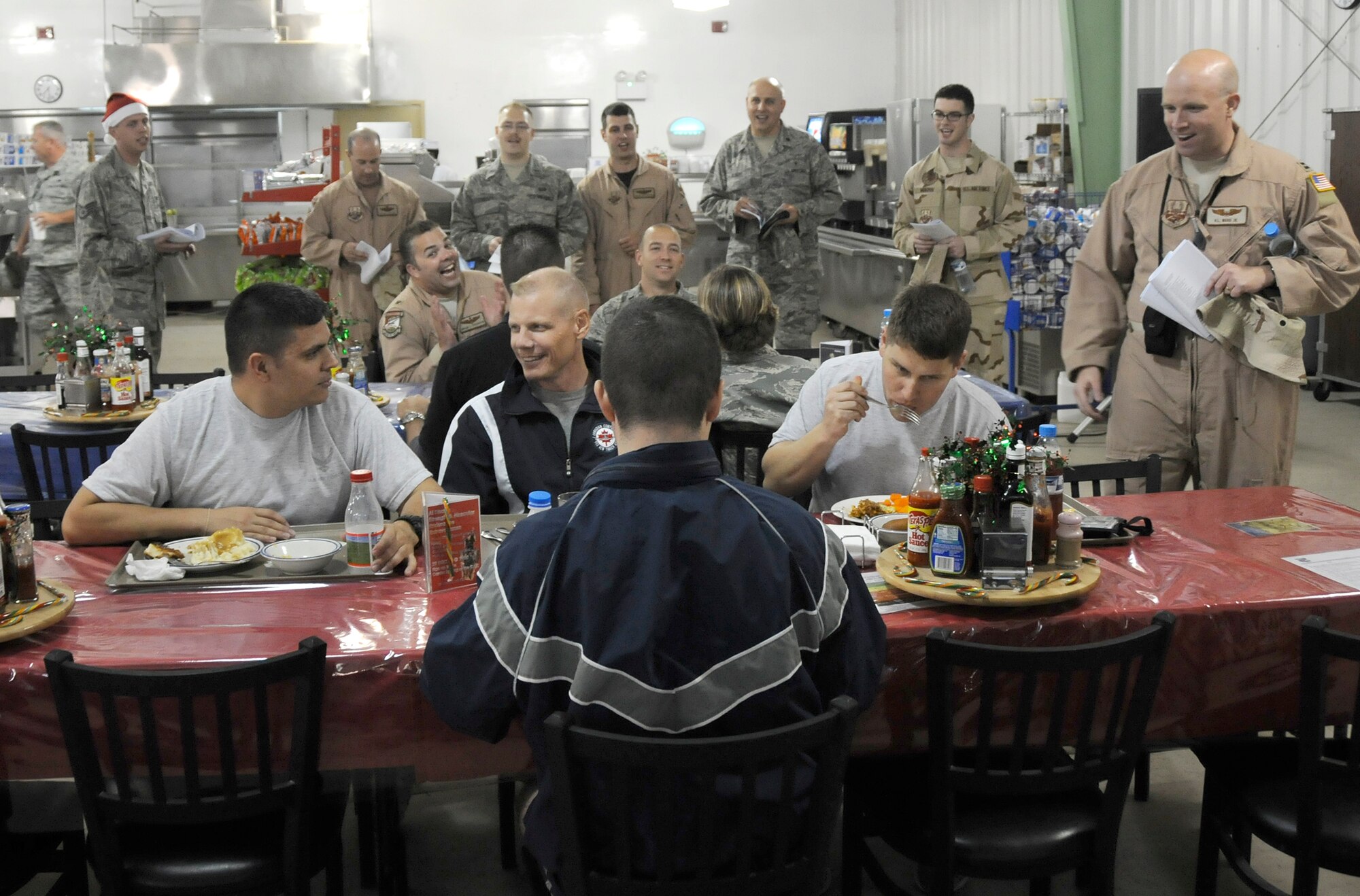 SOUTHWEST ASIA -- Members of the 380th Air Expeditionary wing sing Christmas carols at the Oasis Dining Facility here Dec. 24. The 380th celebrated the holidays with a variety of events throughout the week of Christmas. Members of the Seven Sands Chapel spread holiday cheer with their voices traveling around the base providing a little taste of home by singing various carols. (U.S. Air Force photo/Tech. Sgt. Christopher A. Campbell) (released)