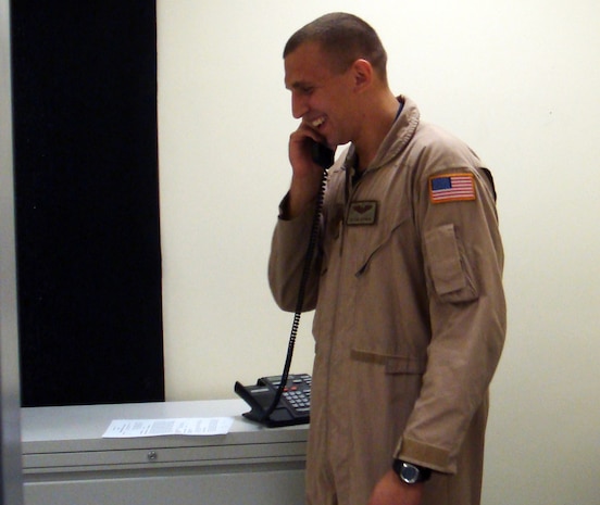 Senior Airman Dan Gutowski, 816th Expeditionary Airlift Squadron loadmaster, talks on the phone with President George W. Bush Christmas eve. Airman Gutowski was one of nine military members  in the area of responsibility to receive the honor. (Courtesy photo)                               