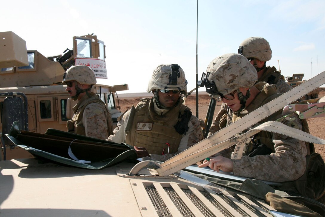 Lance Cpl. Kenneth Magobet, Jr. and Lance Cpl. James Hall from Weapons Company, 1st Battalion, 2nd Marine Regiment, Regimental Combat Team 5, plot trajectories on a mortar board during a tactical air control party live-fire exercise in western al-Anbar province, Iraq, Dec. 27.::r::::n::