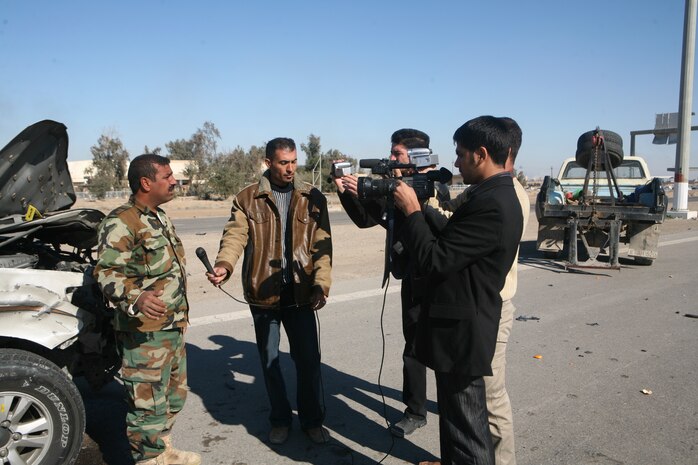 News crews interview Iraqi policemen with the Karmah police Station after a suicide attack on a local highway in Fallujah, Iraq, Dec. 28. Iraqi Security Forces were quick to respond to the situation and provided casualty assistance to injured personnel.