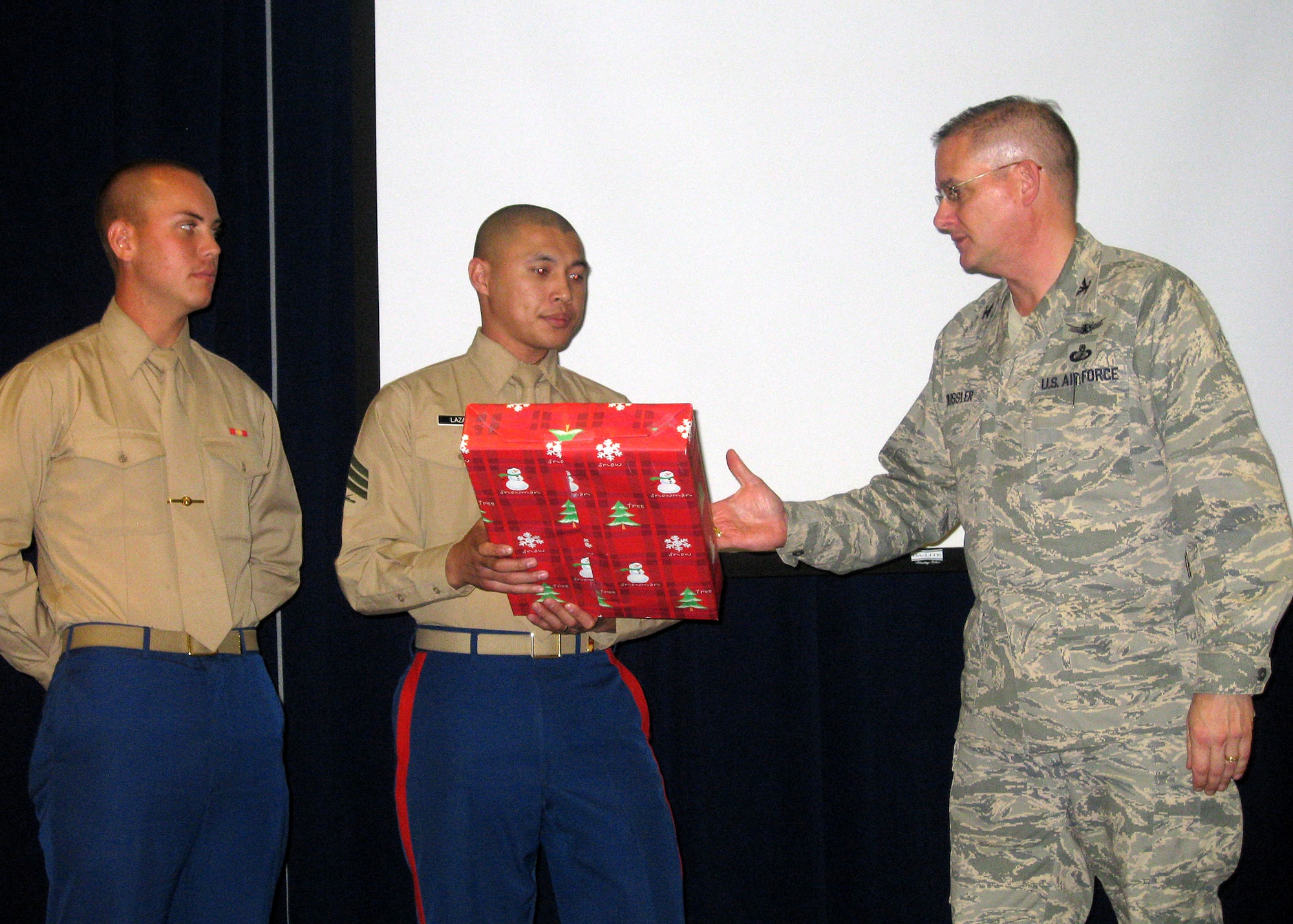 Col. Donald Wussler, Global Positioning Systems Wing vice commander, presents a gift to the representatives from the Culver City United States Marine Corps’ “Toys for Tots” Foundation during the GPSW holiday party, Dec. 5. GPSW collected 180 toys in support foundation. Each year, the wing sponsors a different local charity to deliver toys to needy children during the holiday season. (File photo)