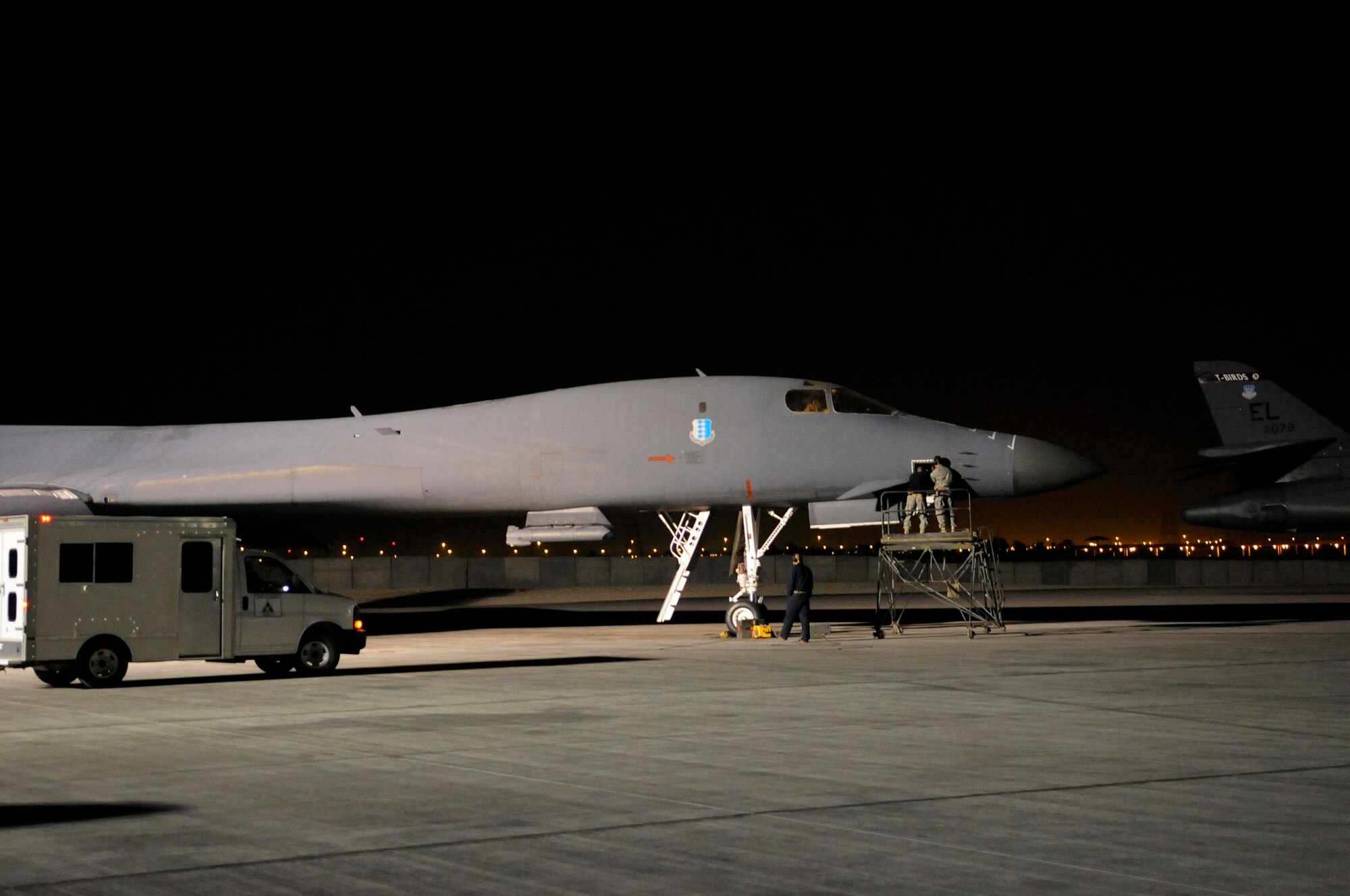Senior Airman Adam Hall and Senior Airman Peter Yurgin (on maintenance stand) replace a part Dec. 28 on a B-1B Lancer receiving maintenance at an air base in Southwest Asia.  The Airmen are aircraft maintenance journeymen assigned to the 379th Expeditionary Aircraft Maintenance Squadron.  (U.S. Air Force photo/Tech. Sgt. Michael Boquette)