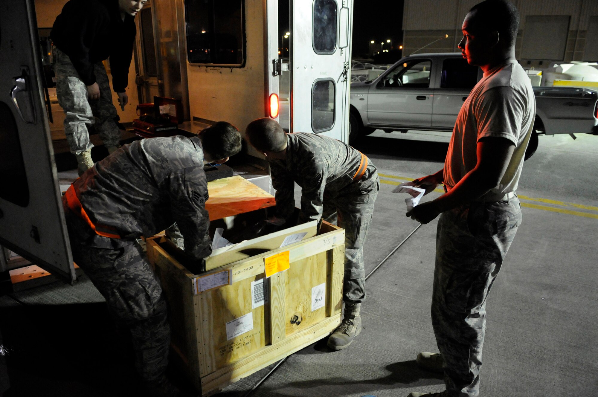 Staff Sergeant Daniel Harrington (right) awaits a signature on a delivery receipt, while Senior Airman Adam Hall, Senior Airman Peter Yurgin and Airman 1st Class Cody Pratt unpack a part Dec. 28 for a B-1B Lancer receiving maintenance at an air base in Southwest Asia.  Sergeant Harrington is supply journeyman assigned to the 379th Expeditionary Logistics Readiness Squadron.  Airmen Hall, Yurgin and Pratt are maintainers with the 379th Expeditionary Aircraft Maintenance Squadron.  (U.S. Air Force photo/Tech. Sgt. Michael Boquette)