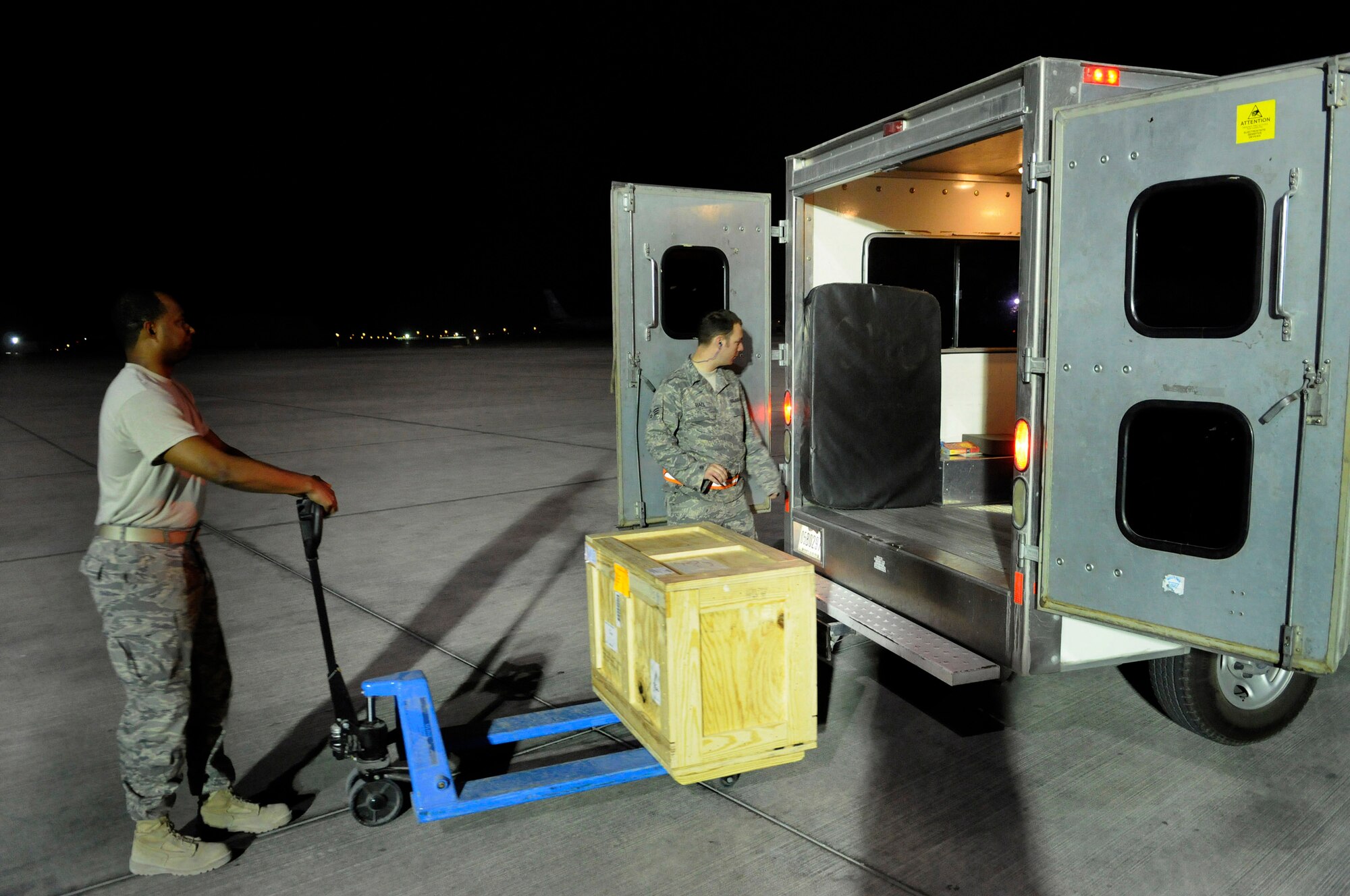 Staff Sgt. Daniel Harrington (left) delivers an aircraft part to Senior Airman Adam Hall Dec. 28 on the flightline of an air base in Southwest Asia.  The supply team runs the consolidated aircraft parts facility, a collocated facility where all maintenance teams can go to pick up items needed to fix their specific aircraft.  Sergeant Harrington is supply journeyman assigned to the 379th Expeditionary Logistics Readiness Squadron.  Airman Hall is an aircraft maintenance journeyman assigned to the 379th Expeditionary Aircraft Maintenance Squadron.  (U.S. Air Force photo/Tech. Sgt. Michael Boquette)