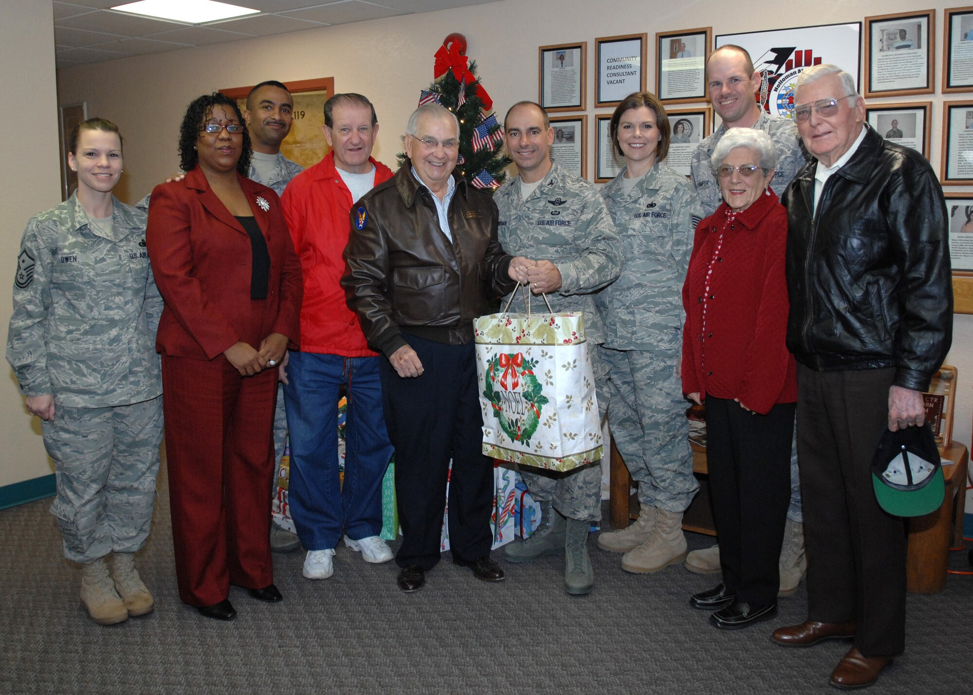 The Military Officer's Association of America pose for a group photo with Col. Jeff Harrigian, 49th Fighter Wing commander, after dropping off presents at Holloman Air Force Base, N.M., Dec. 19. Retired officers gathered at the Airman and Family Readiness Center to present Col. Jeff Harrigian with gifts for children of Holloman. (U.S. Air Force photo/Airman 1st Class Veronica Salgado)