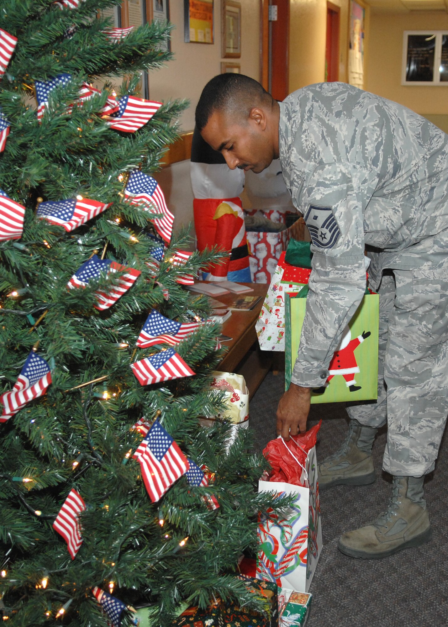 Master Sgt. Calvin Mason, 49th Communication Squadron first sergeant, gathers presents donated by the Military Officer's Association of America at Holloman Air Force Base, N.M., Dec. 19. First sergeants helped distribute the gifts to children of Holloman at the Airman and Family Readiness Center. (U.S. Air Force photo/Airman 1st Class Veronica Salgado)