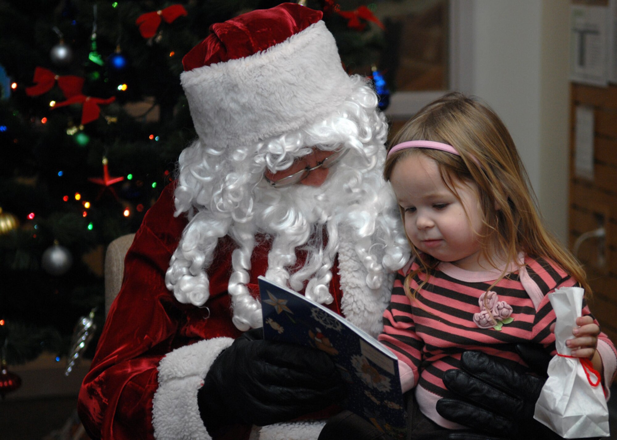 Kaytlyn Barrett sits on Santa's lap at Ahren's Memorial library at Holloman Air Force Base, N.M., Dec. 17. A bag of candy and a reading book were given to all children who attended story time with Santa. (U.S. Air Force photo/Airman 1st Class Veronica Salgado)